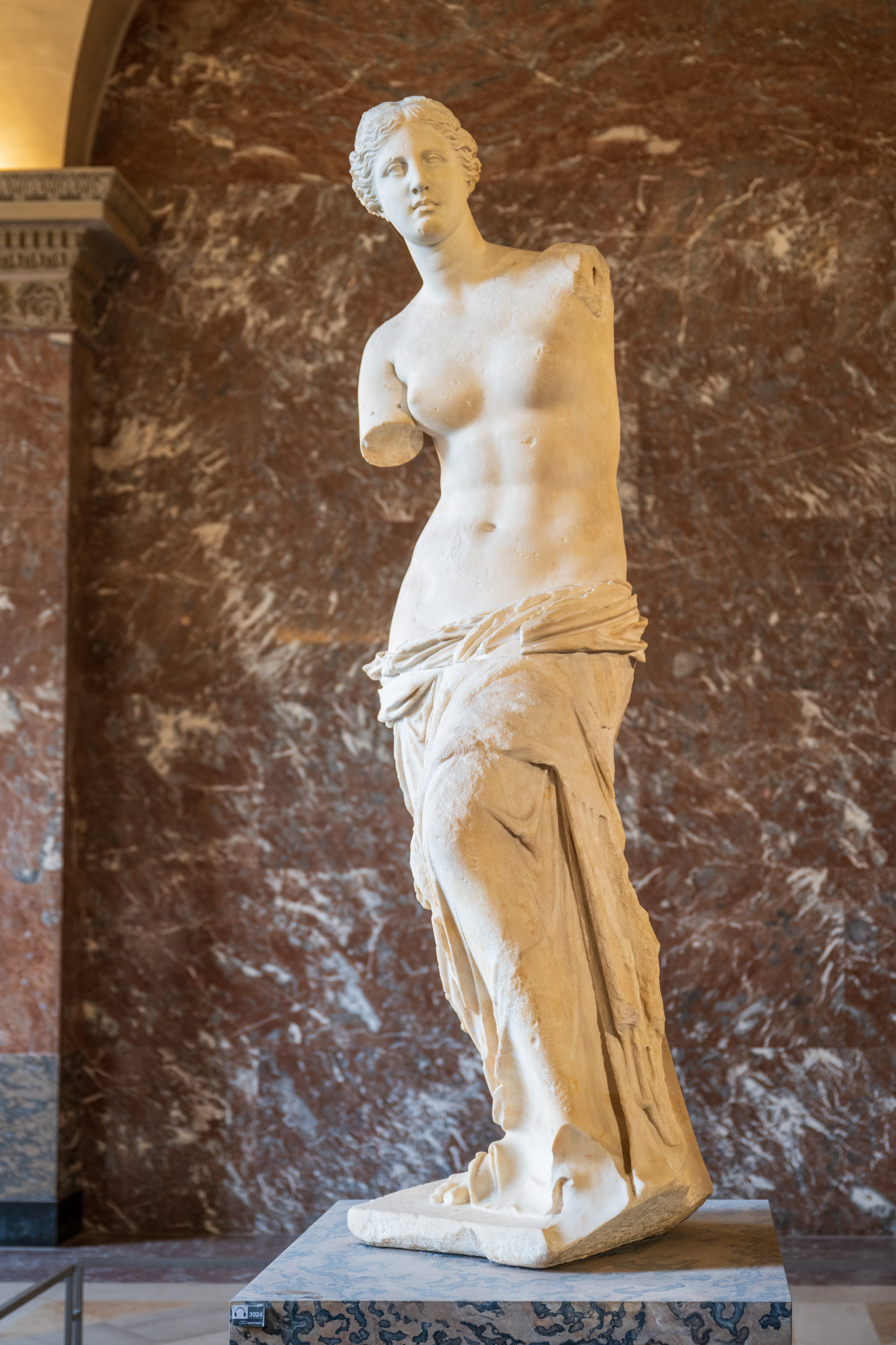 Classical marble statue of Venus de Milo, a celebrated  past  Greek sculpture, displayed connected  a pedestal successful  a depository  setting