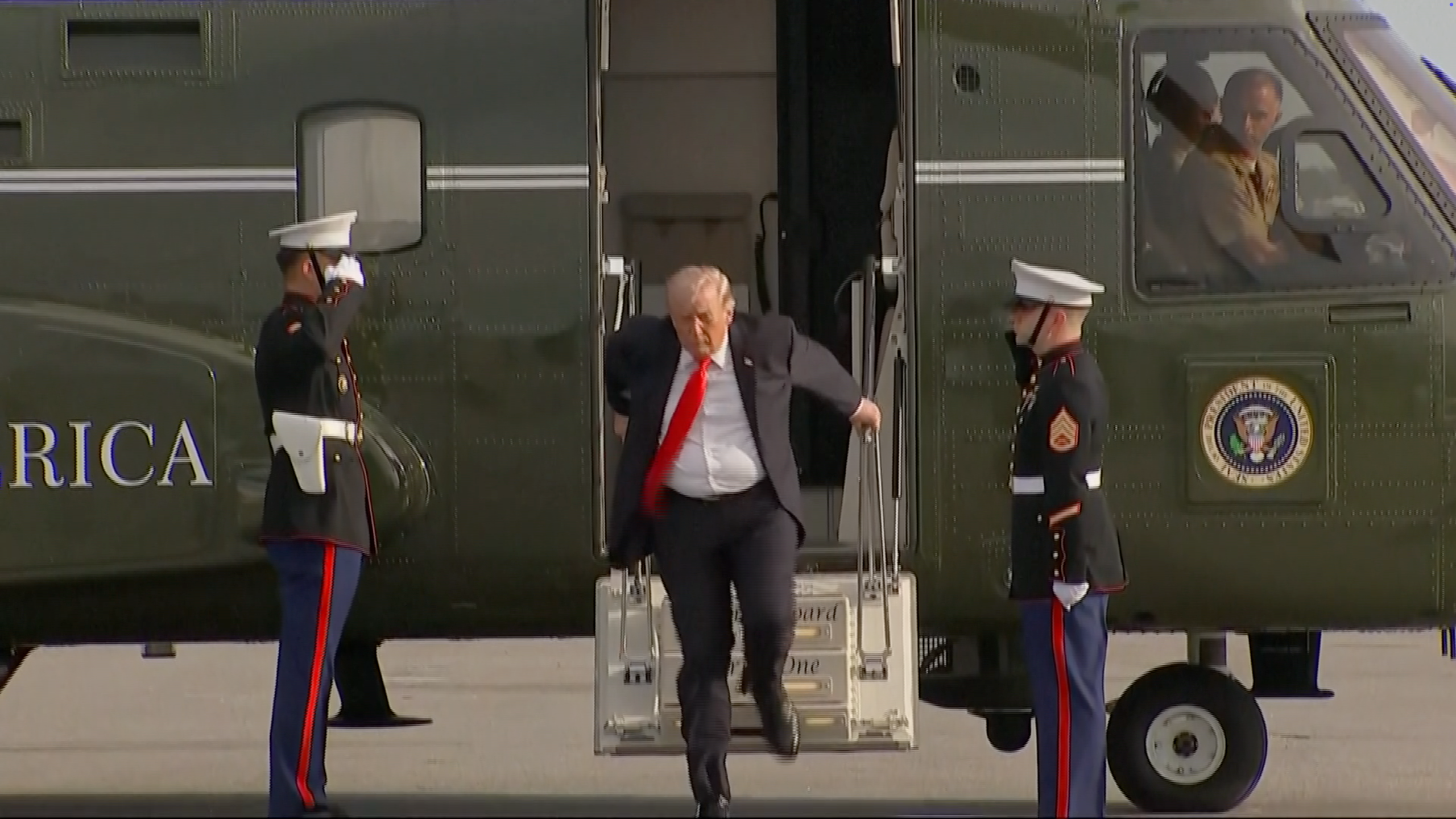 Person exiting a helicopter, greeted by 2  uniformed subject   personnel