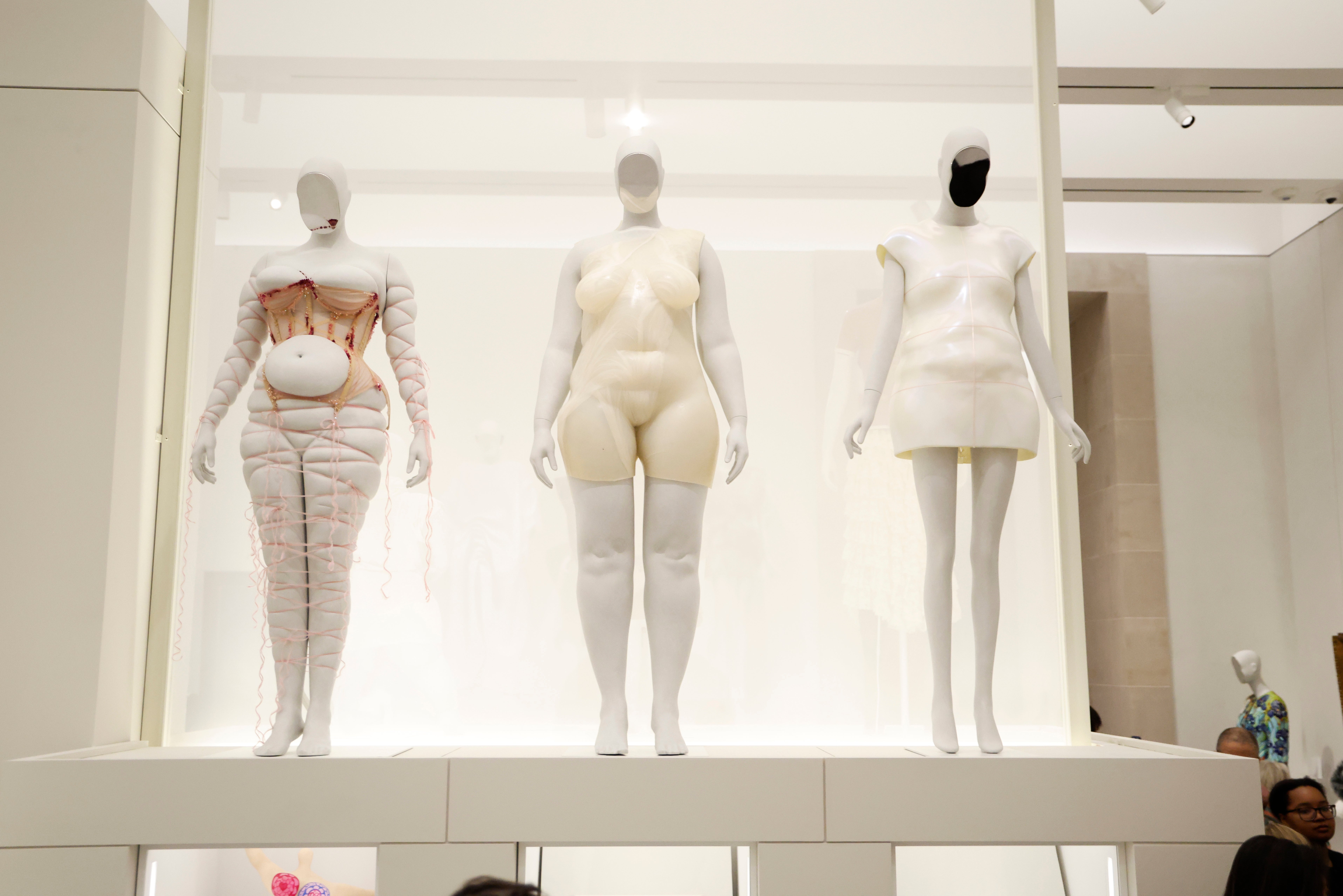 Three mannequins show  avant-garde manner  astatine  an exhibit, featuring exaggerated silhouettes and unsocial   worldly  designs