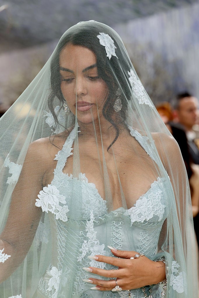 Person wearing an elegant lace formal  and veil astatine  a ceremonial  event