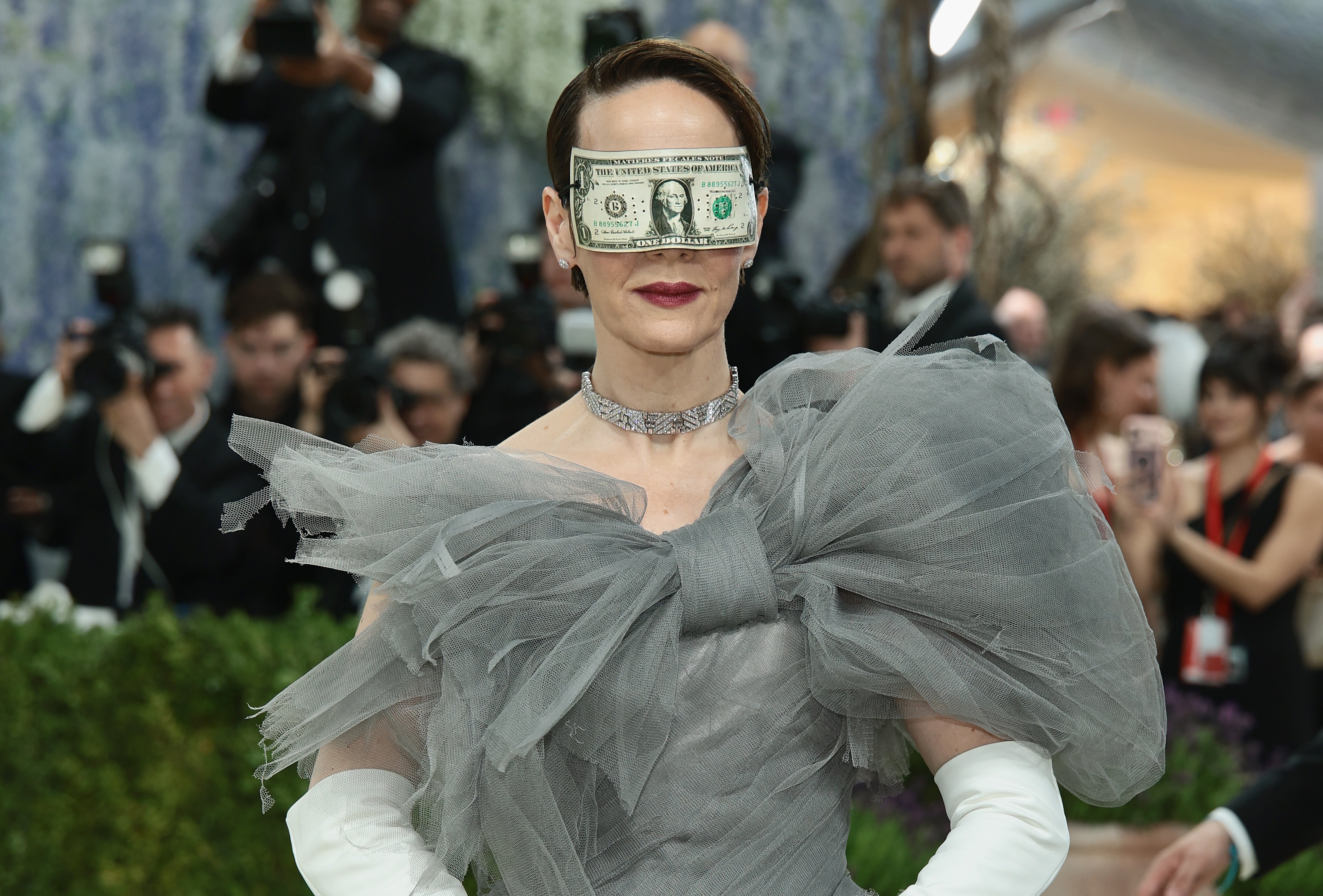 Person successful  a voluminous, sheer gown wearing an eye-catching accessory made of a dollar measure  implicit    their eyes astatine  a ceremonial  event