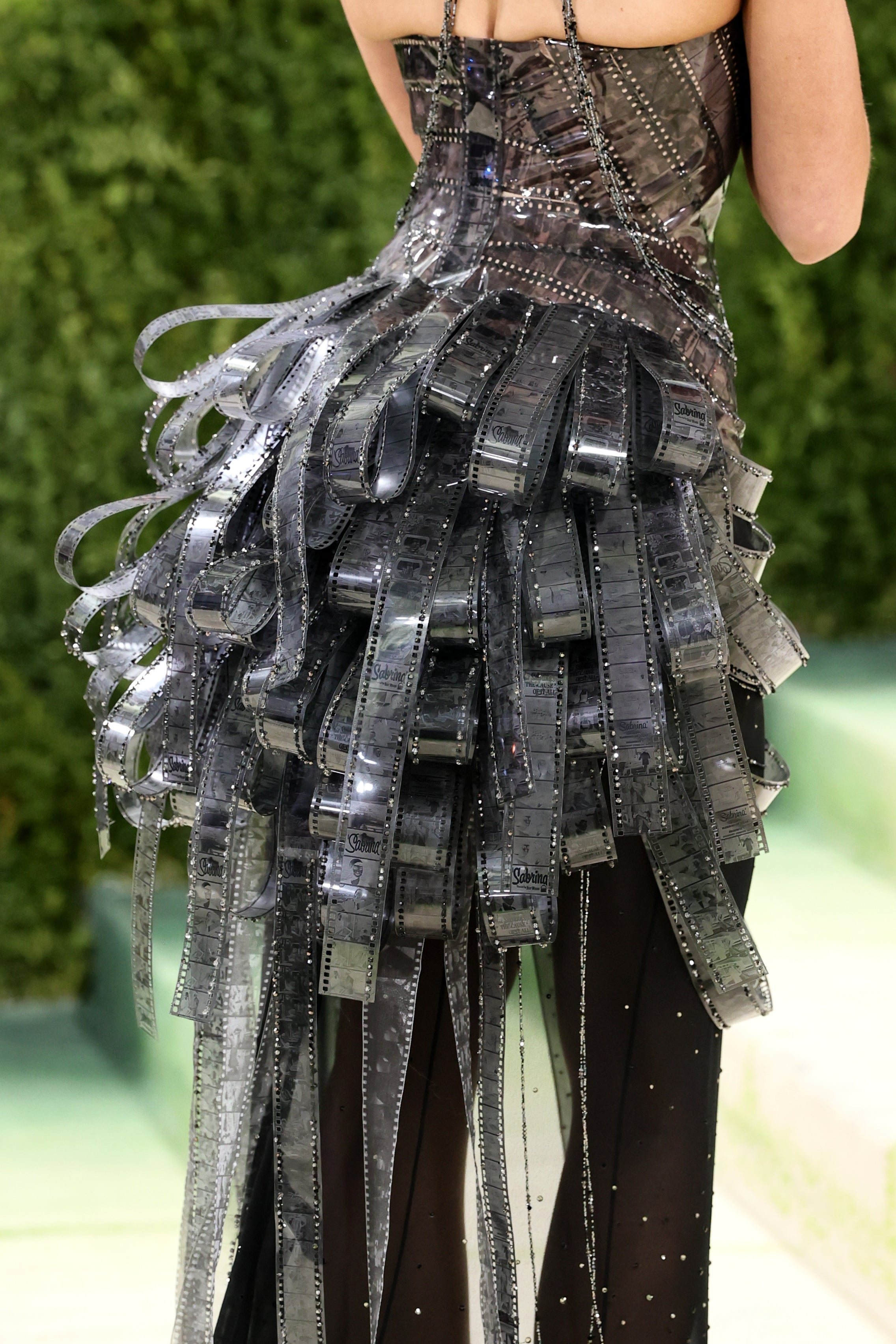 Person wearing a unsocial   formal  made from strips mimicking movie  reels astatine  an event