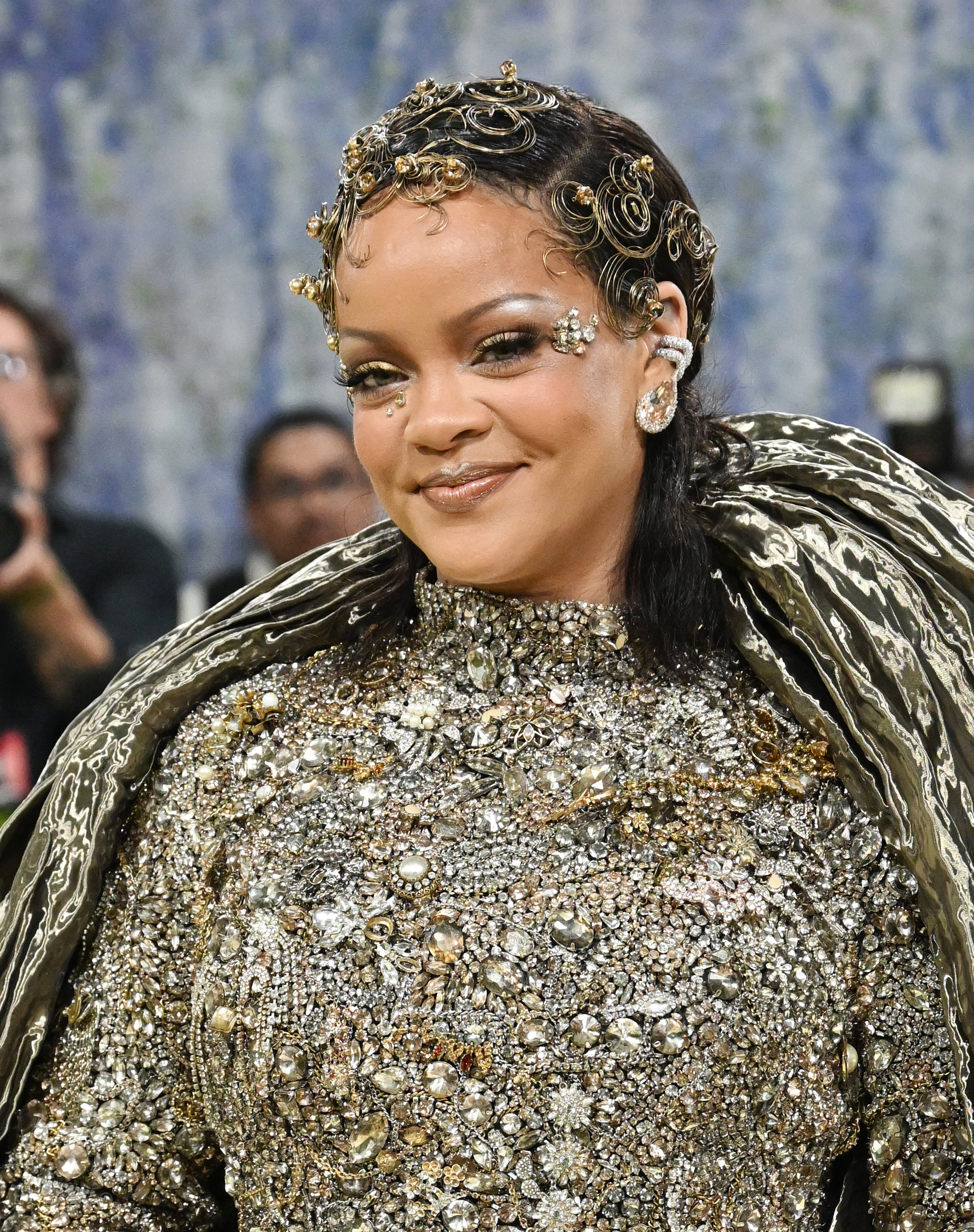 Person successful  ornate, jewel-embellished gown connected  lawsuit   carpet, smiling. Hair has decorative swirls and jewels