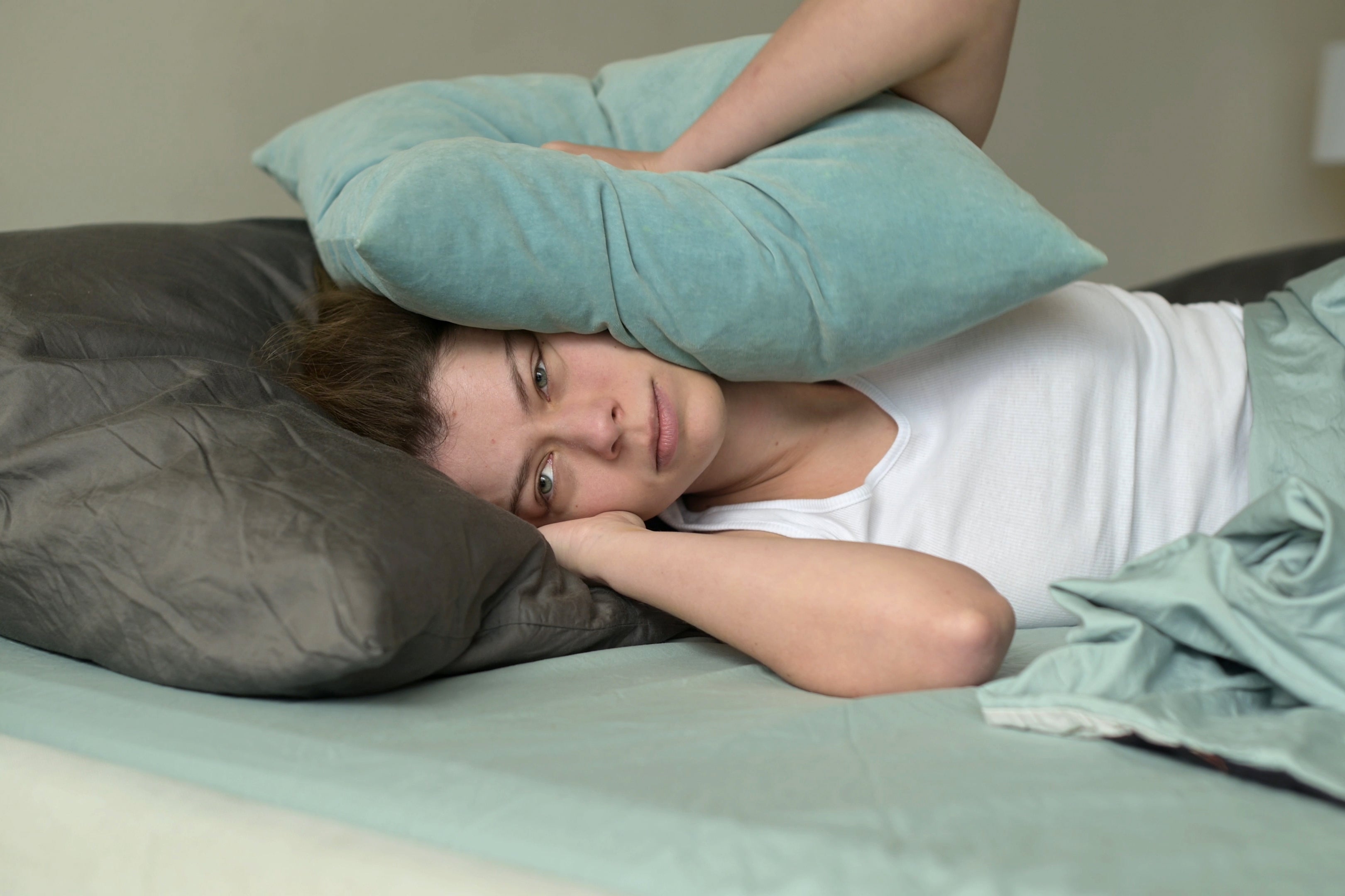 Person successful  furniture  covers caput  with pillow, appears bushed   oregon  frustrated