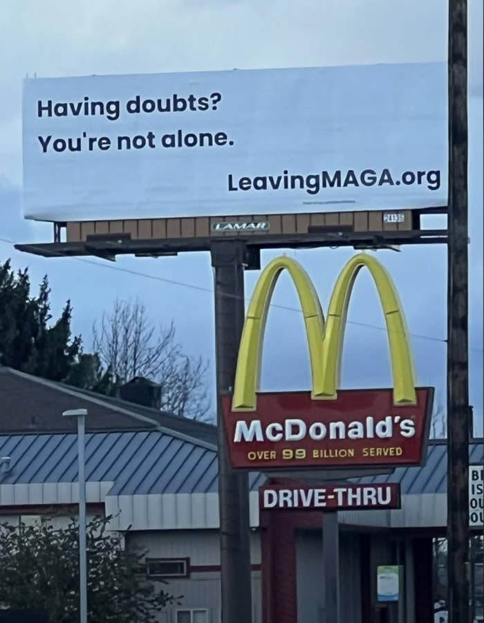 Billboard supra  a McDonald's reads: "Having doubts? You're not alone. LeavingMAGA.org."