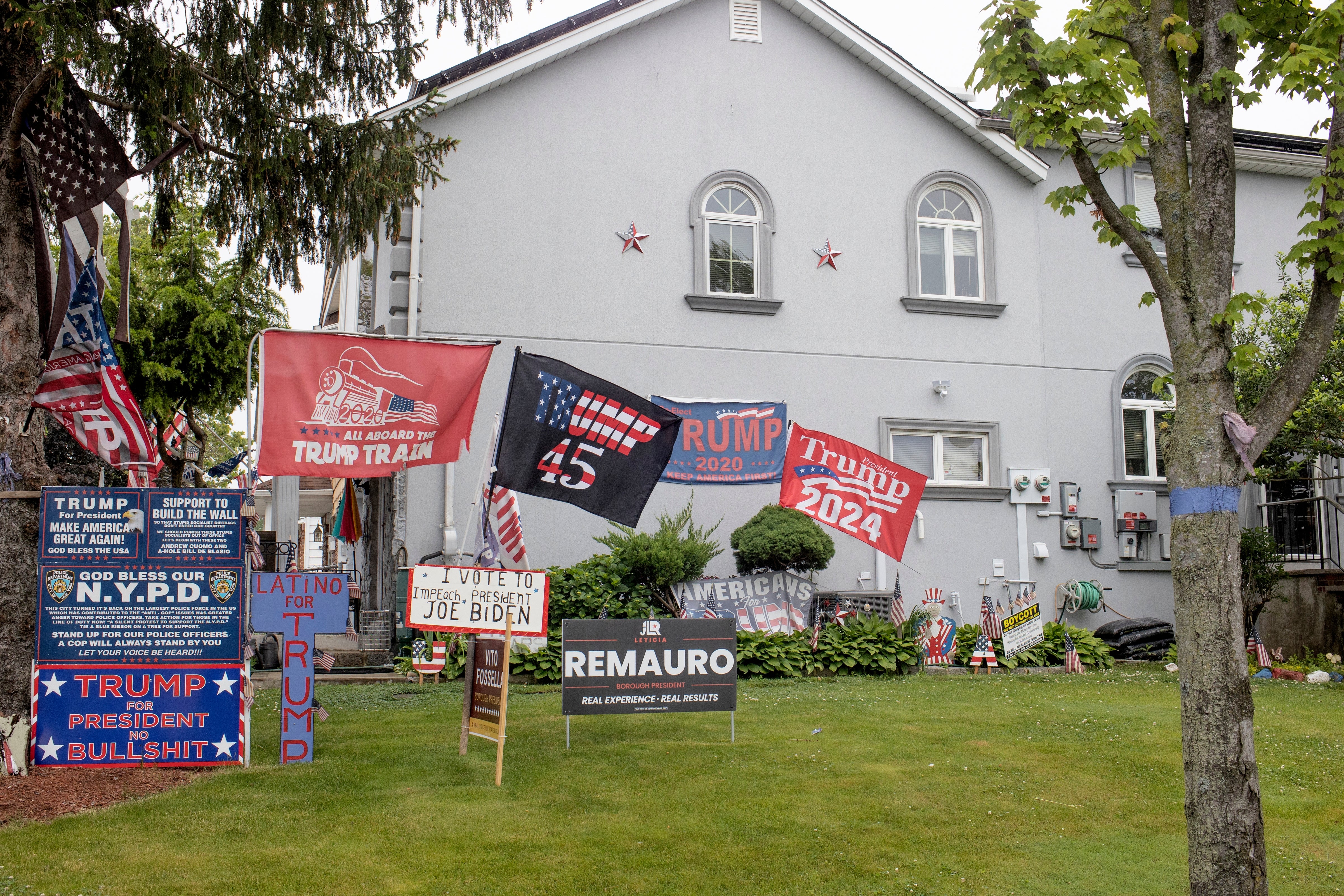 House with aggregate  Trump flags and signs supporting his campaigns and criticizing Joe Biden successful  the yard