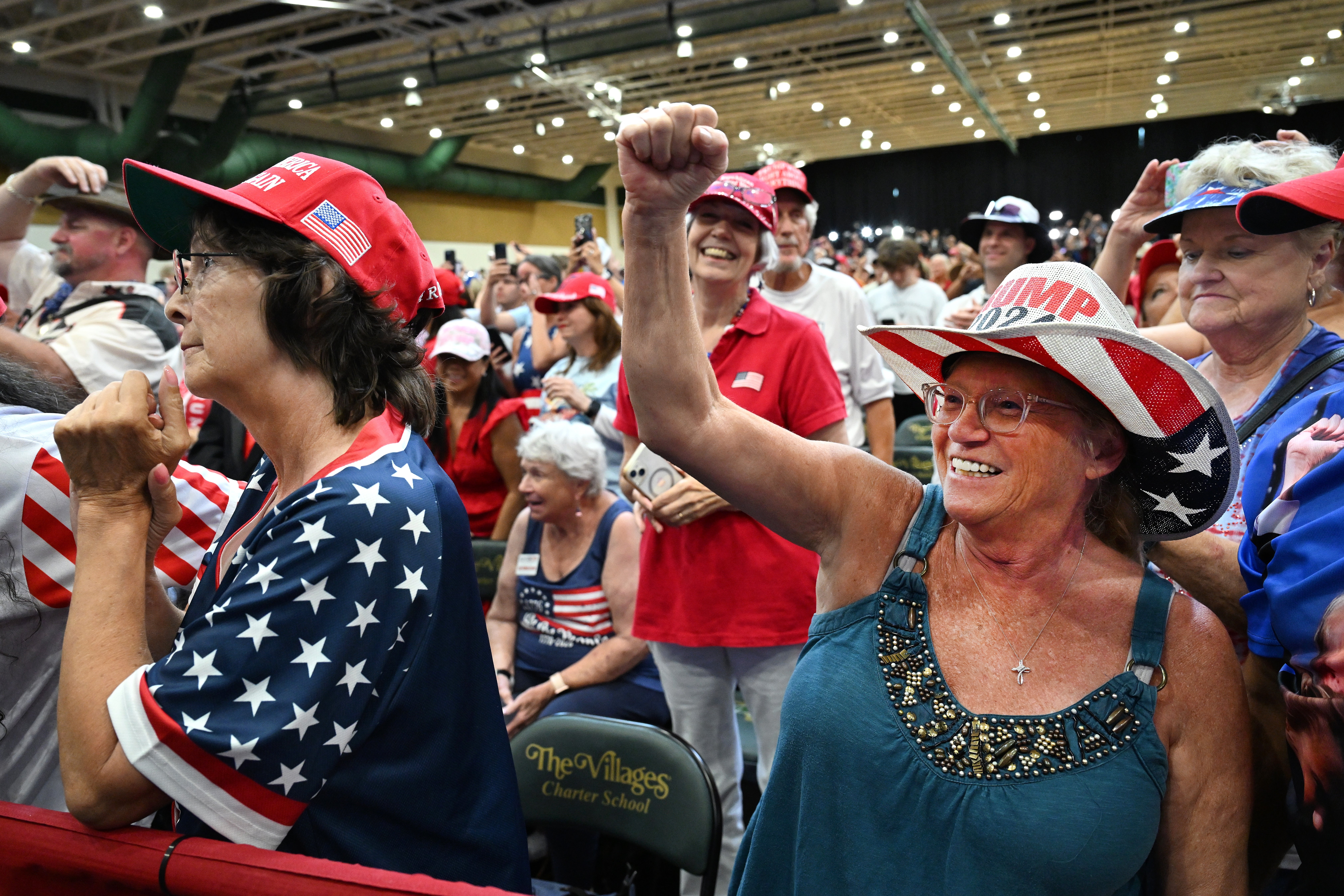 Crowd of radical   astatine  a rally, with attendees wearing patriotic-themed clothing, immoderate   raising fists successful  enthusiasm