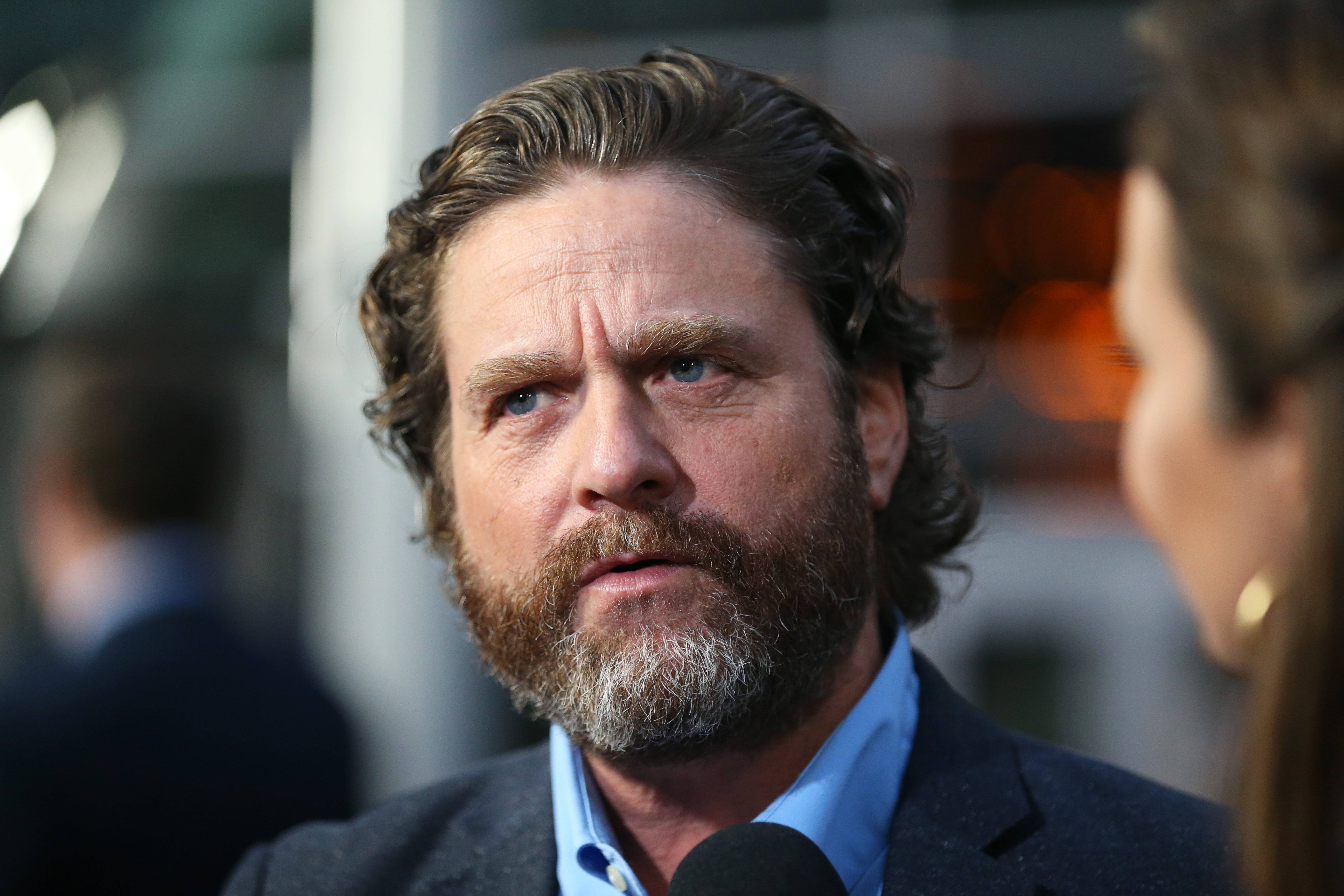 Man speaking during a nationalist   event, successful  a suit, with a thoughtful expression. Microphone disposable   successful  front