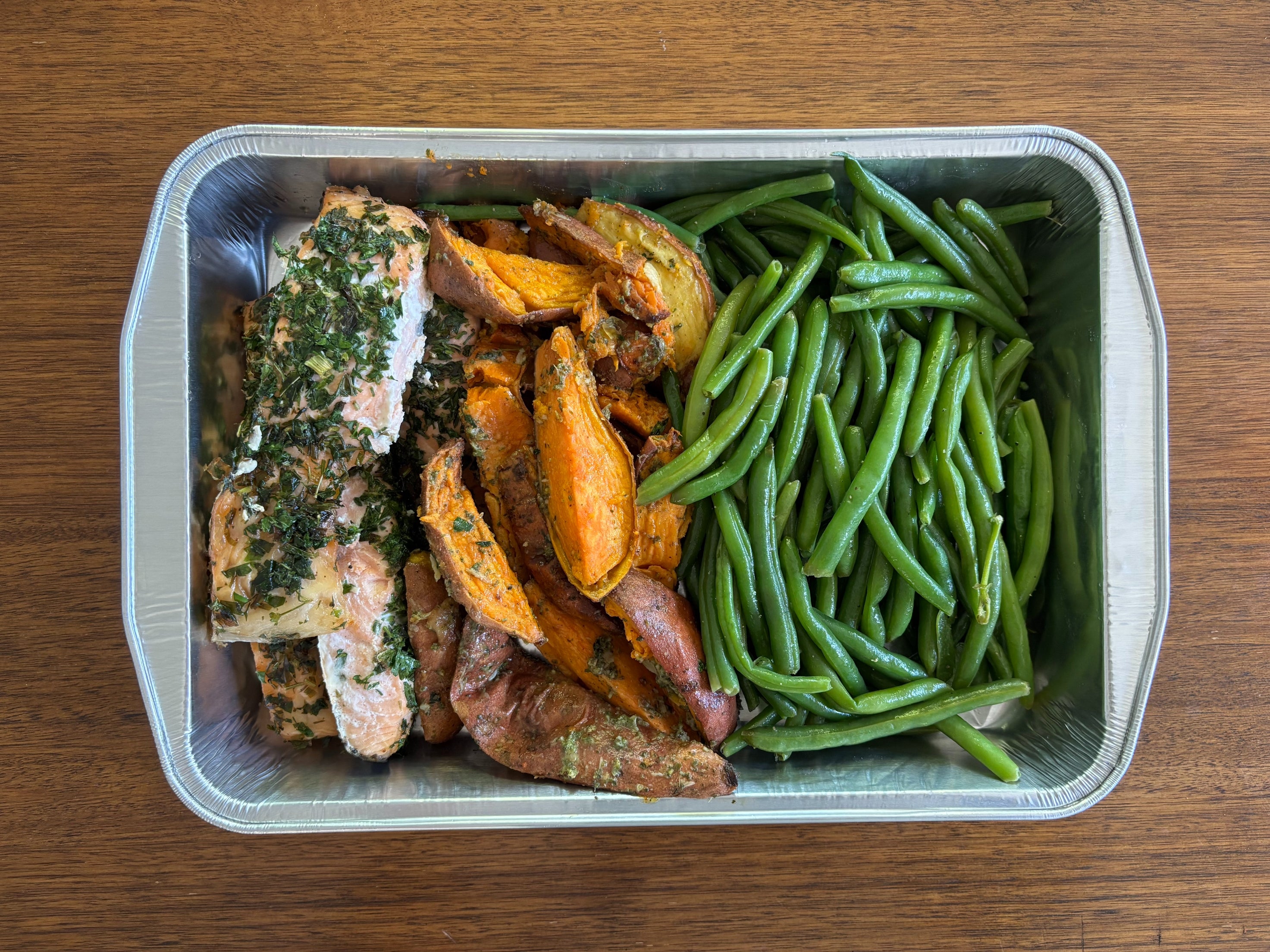 Tray with salmon, roasted sweet potato wedges, and green beans