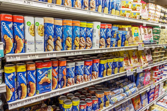 Grocery store shelves stocked with various brands of crescent rolls, biscuit dough, and baking products
