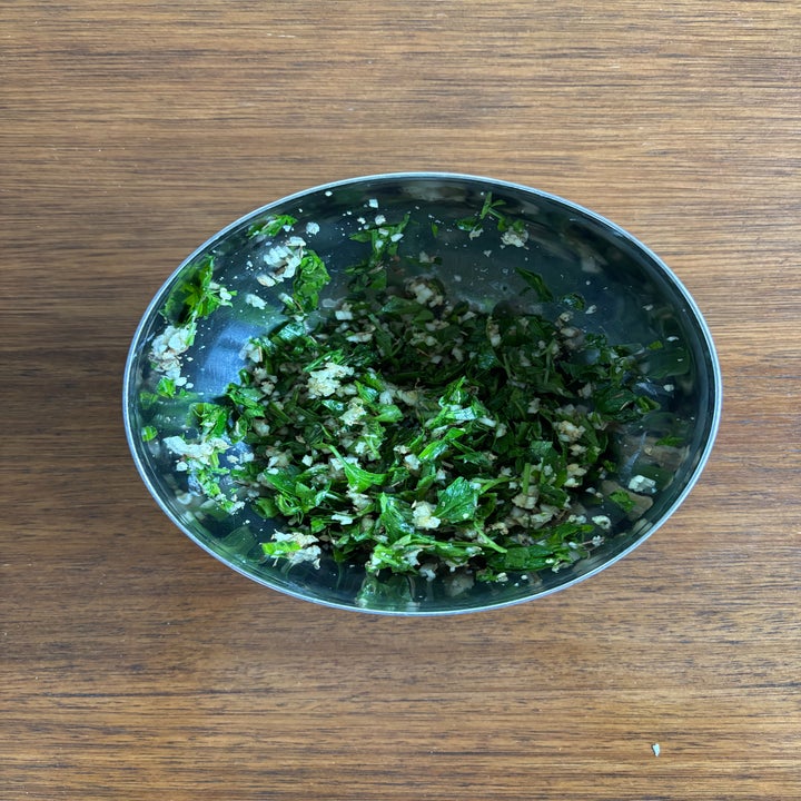 A bowl of chopped herbs and minced garlic