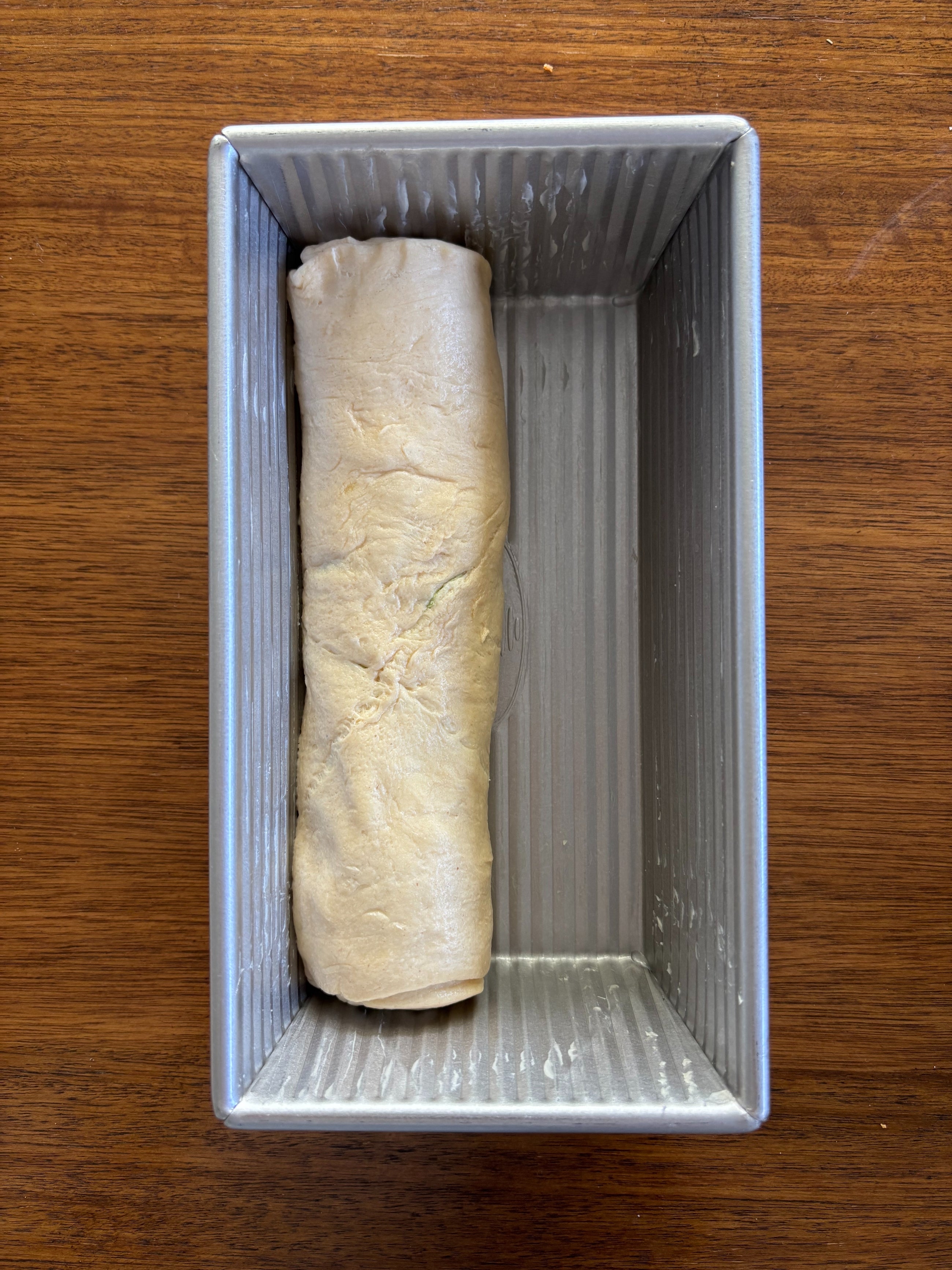 Log of dough inside a loaf pan
