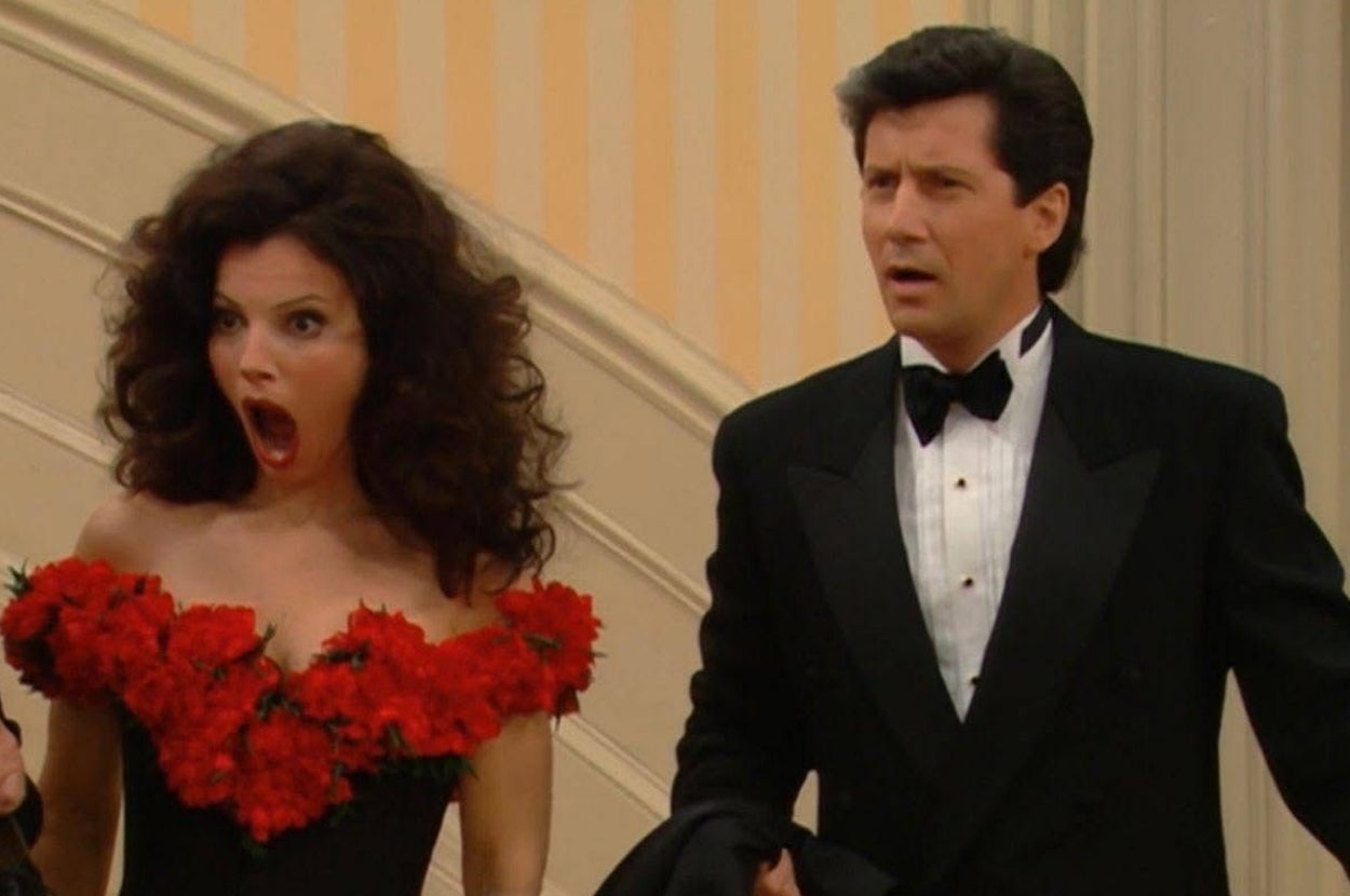 Two people in formal wear are on a staircase; one looks surprised