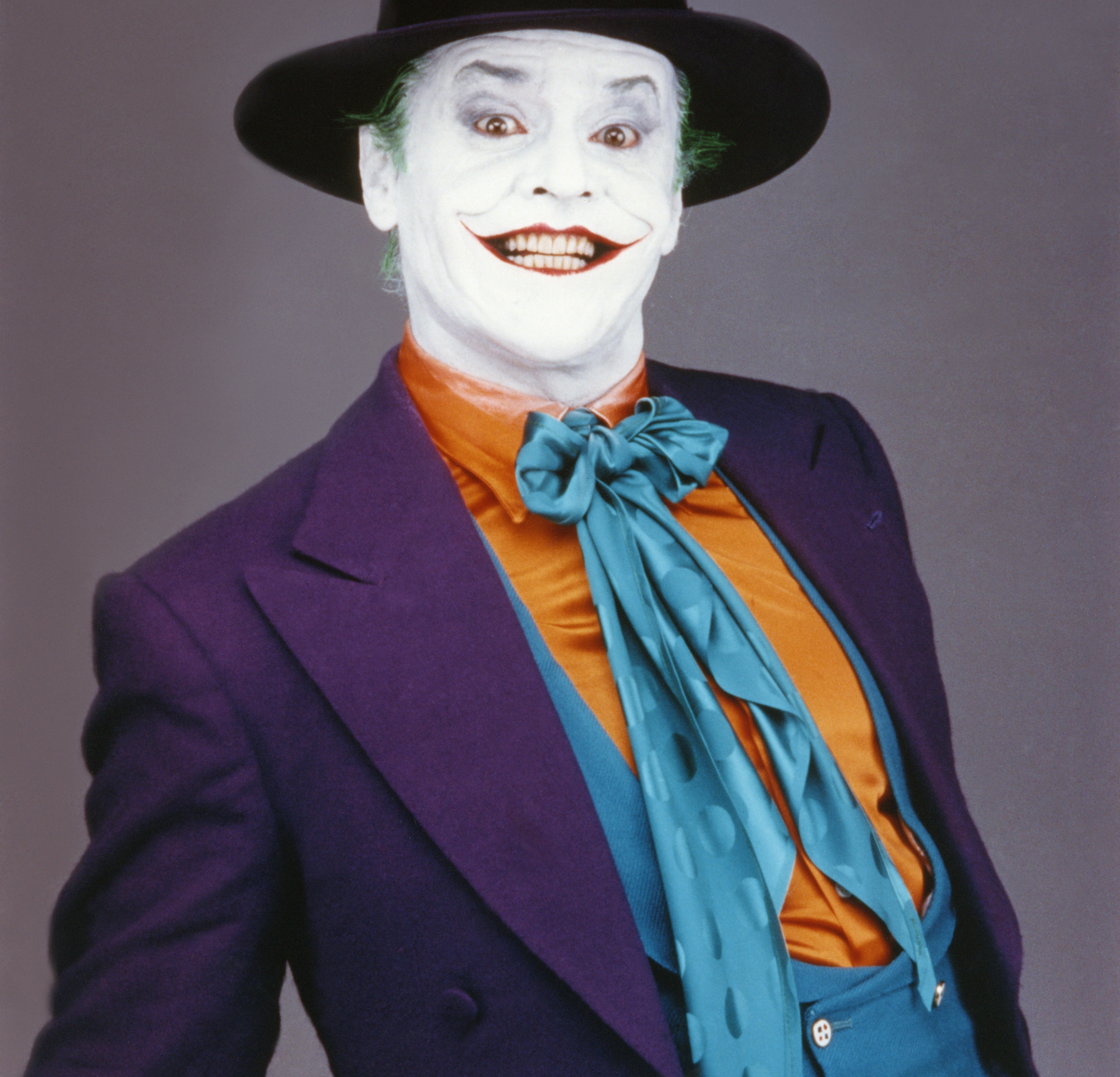A idiosyncratic   successful  theatrical constitution  and costume with a wide-brimmed hat, colorful suit, and exaggerated grin reminiscent of a clown