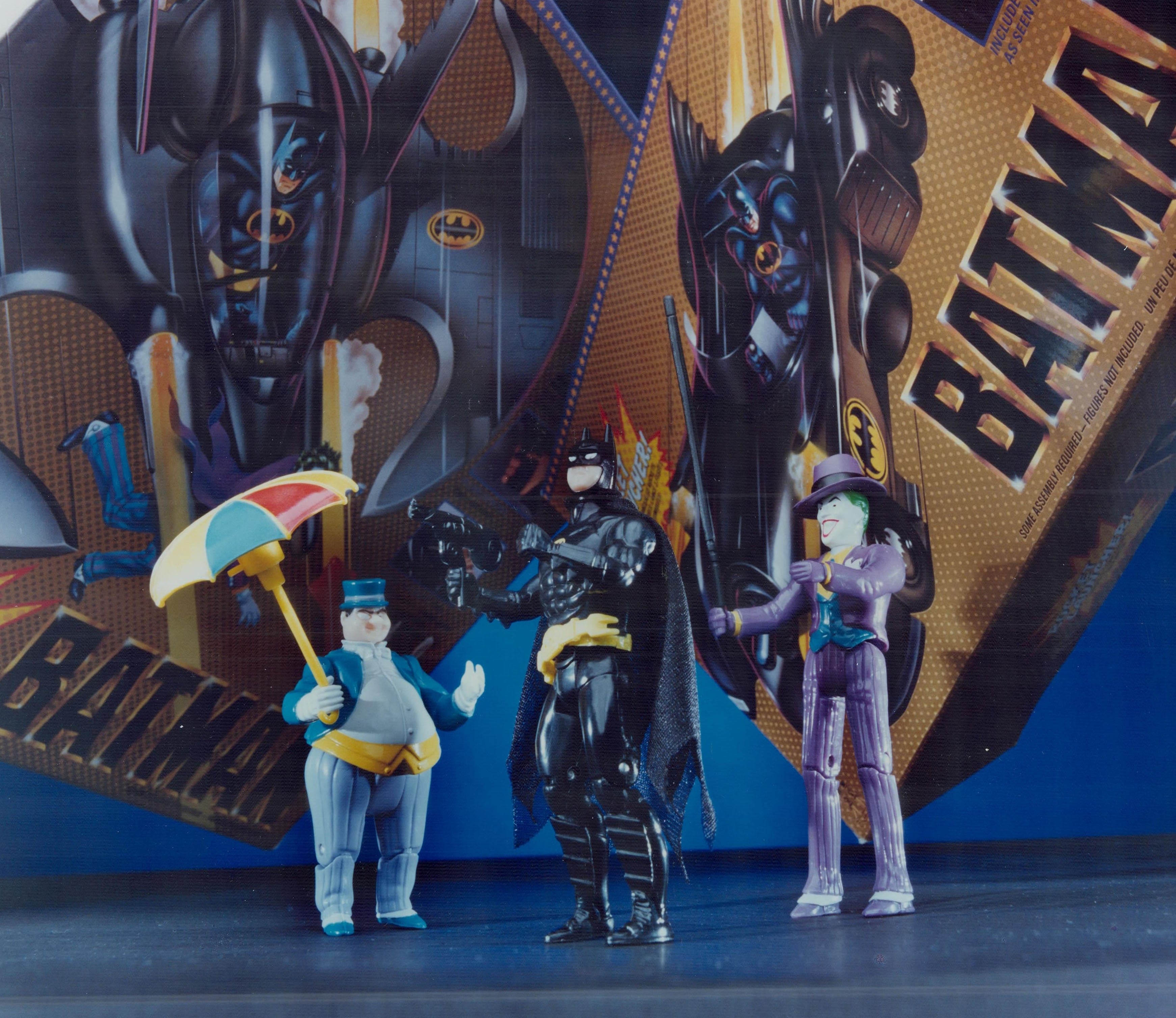 Three Batman enactment   figures, styled arsenic  characters from the Batman universe, basal   successful  beforehand   of a vintage Batman-themed backdrop