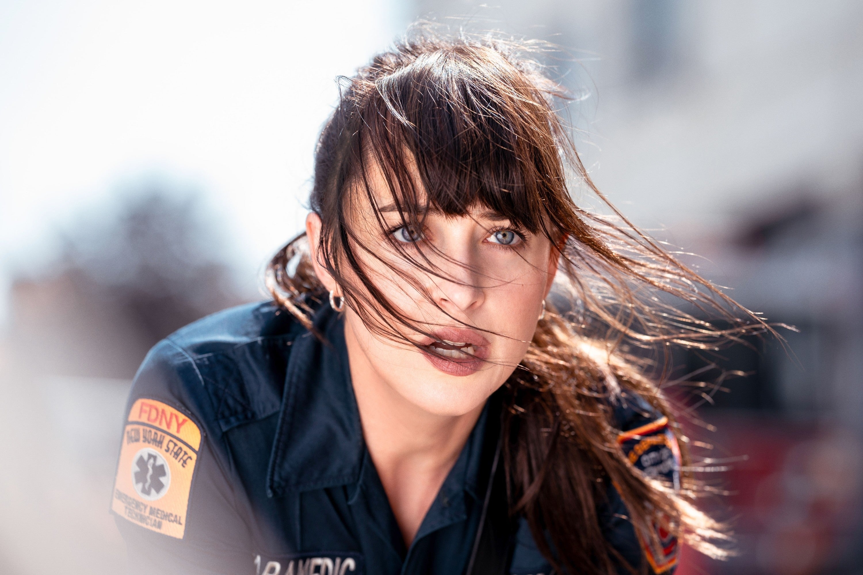 Person successful  firefighter azygous   with windswept hair, looking into the region  with a determined expression