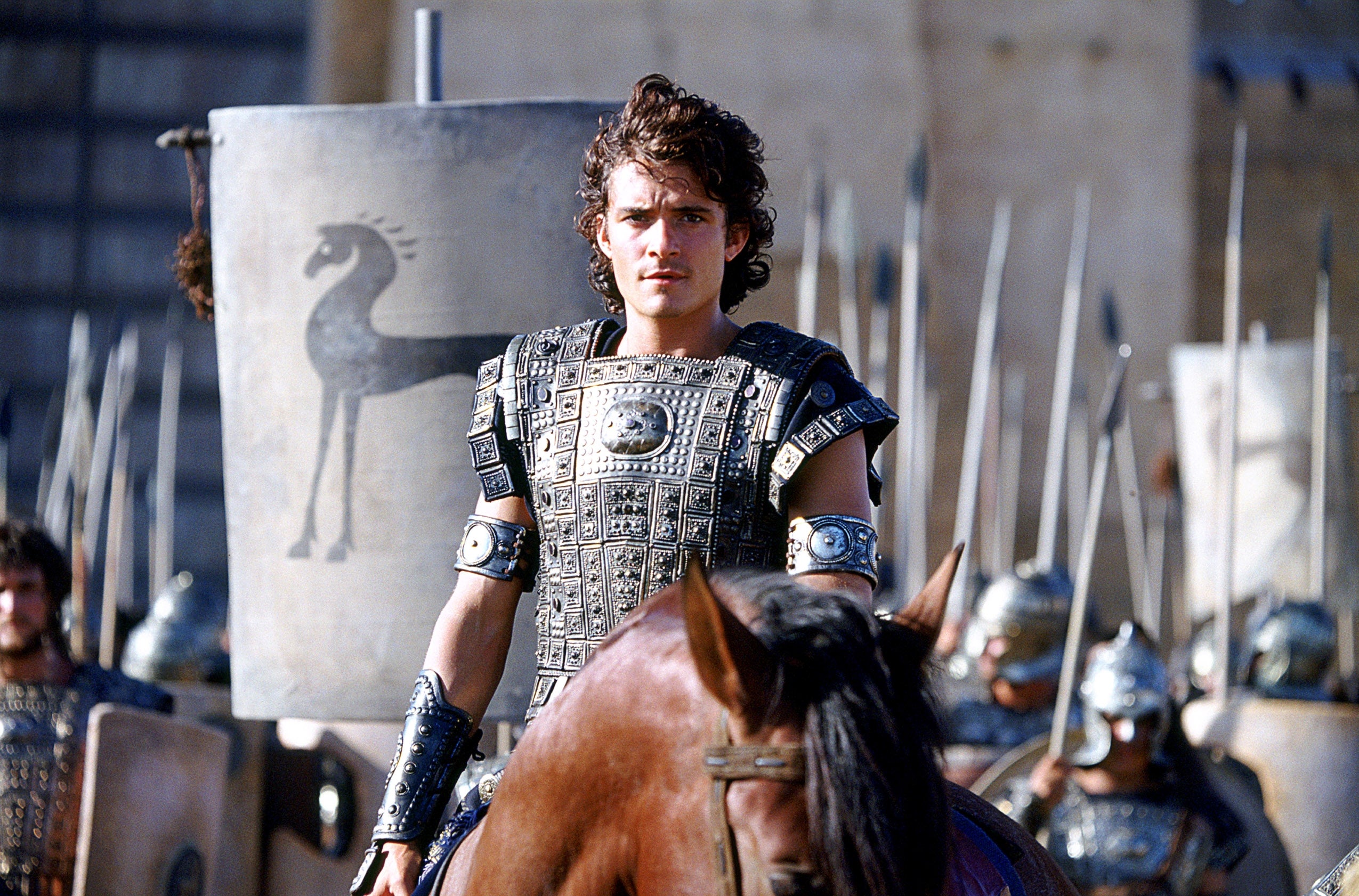 Person successful  elaborate  past  armor connected  a horse, successful  beforehand   of soldiers with shields and spears, connected  an past  battlefield set