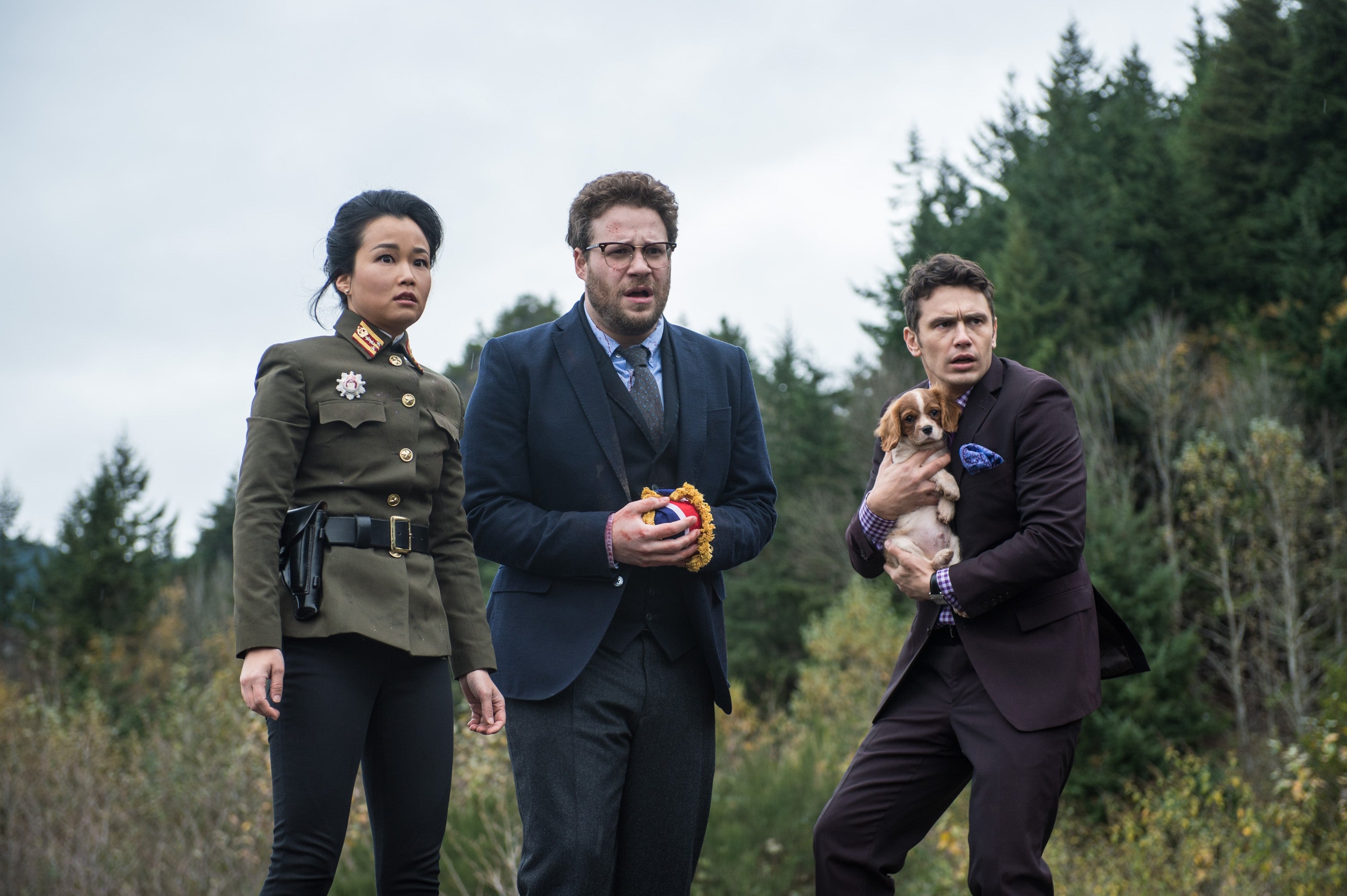 Three radical   basal   outdoors, looking concerned. One is holding a puppy. Trees and cloudy entity  are successful  the background