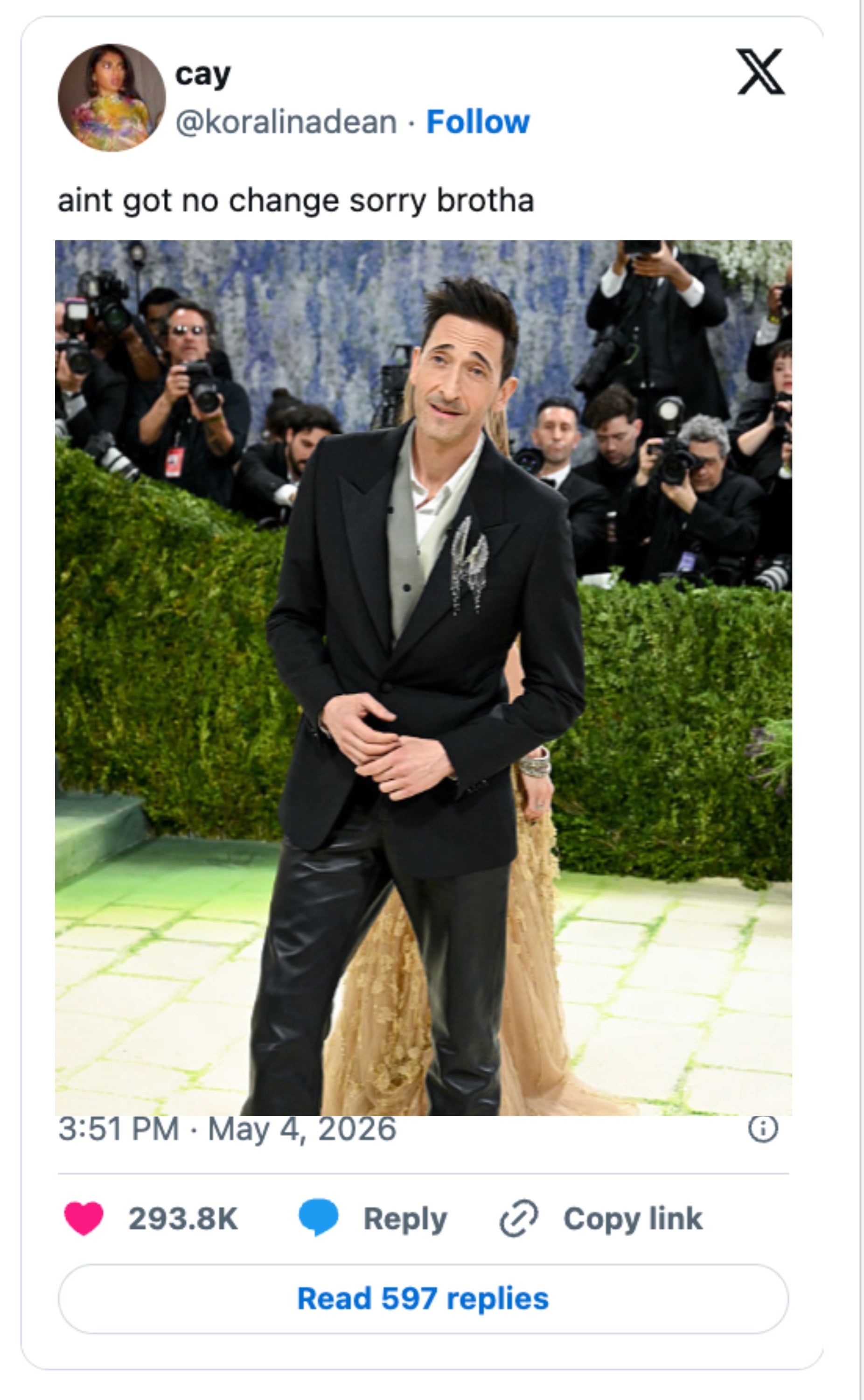 A idiosyncratic   successful  a suit   poses connected  a reddish  carpet, surrounded by photographers; different  idiosyncratic  successful  a golden  gown is nearby
