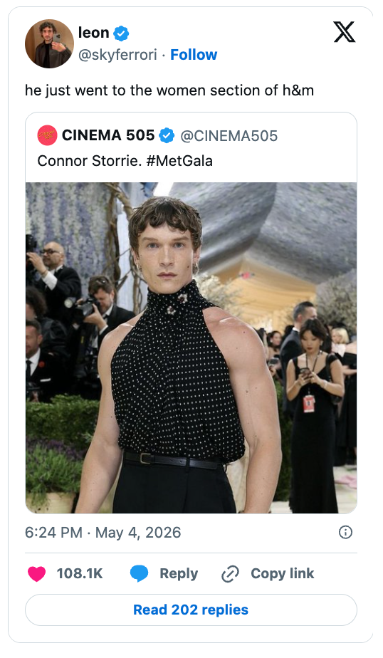 Person successful  sleeveless polka dot apical  and high-waisted pants astatine  a high-profile event. Crowd and media successful  the background