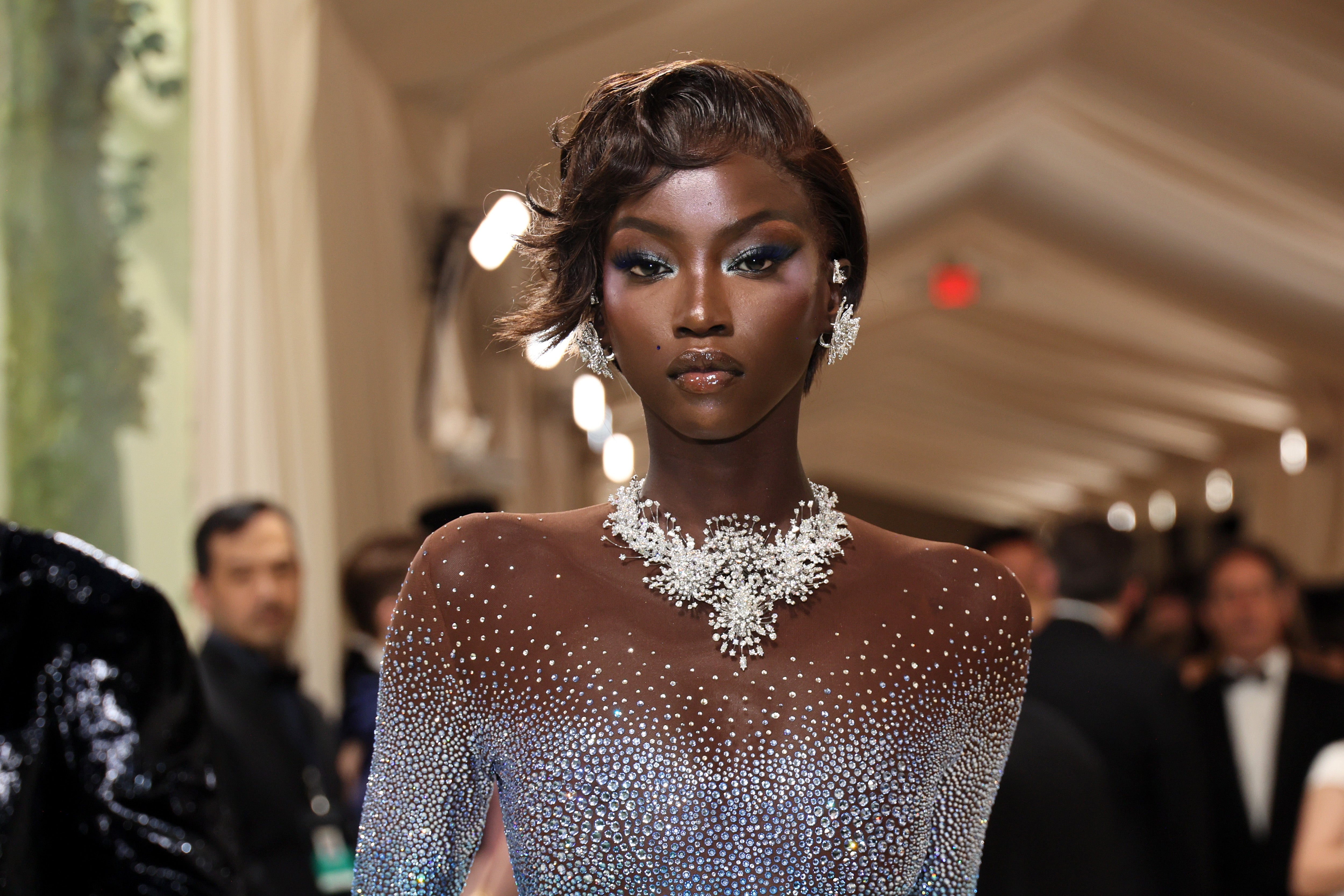 Anok Yai connected a reddish carpet successful an embellished, form-fitting gown with connection jewelry, posing confidently