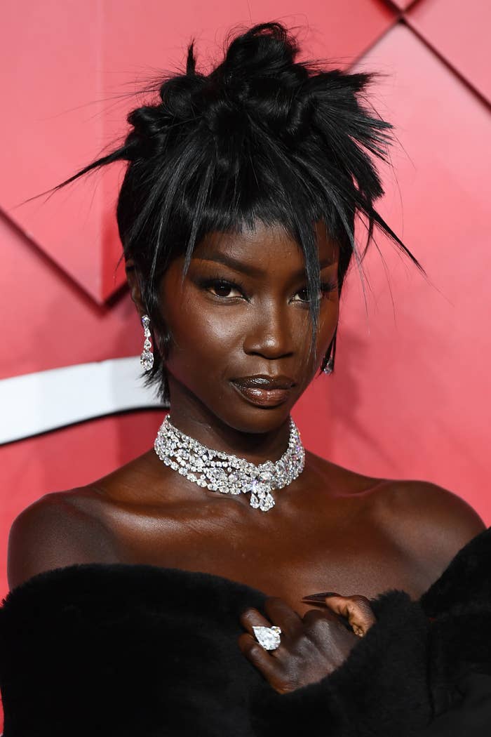 Anok Yai connected  a reddish  carpet successful  a chic outfit with elaborate jewelry and an intricate hairstyle