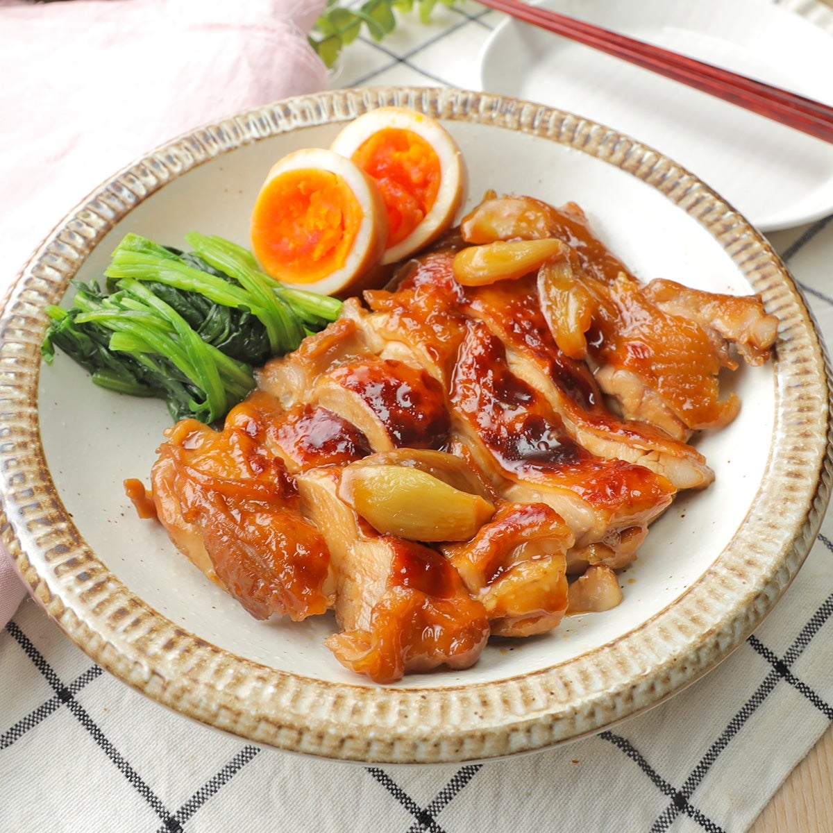 お皿に載った照り焼きチキン、煮卵、ほうれん草。食欲をそそる盛り付け。