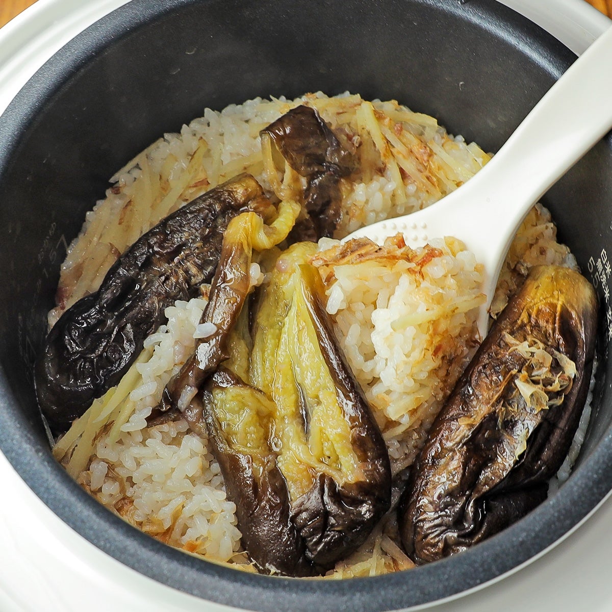 炊飯器内の茄子ご飯。茄子とご飯が混ざって調理されている。