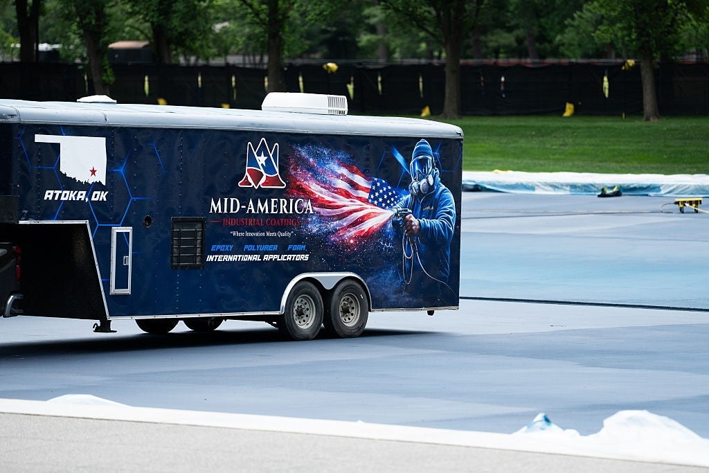 Trailer with "Mid-America Professional Cowboy" branding, featuring a cowboy holding an American flag, parked connected a paved area