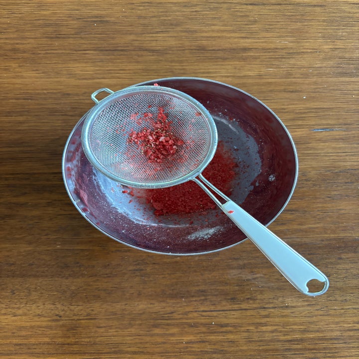 Sifter resting on a bowl with red powder