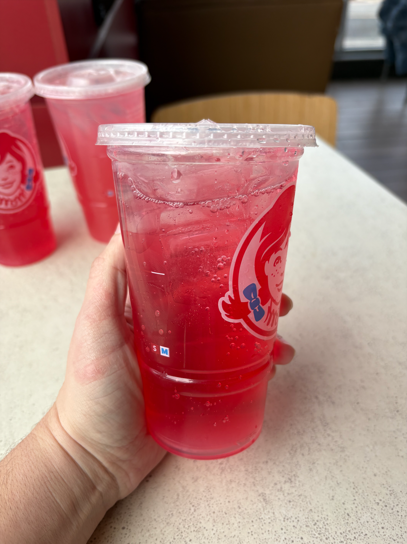 Wendy's Watermelon Sparkling Energy drink being held in someone's hand