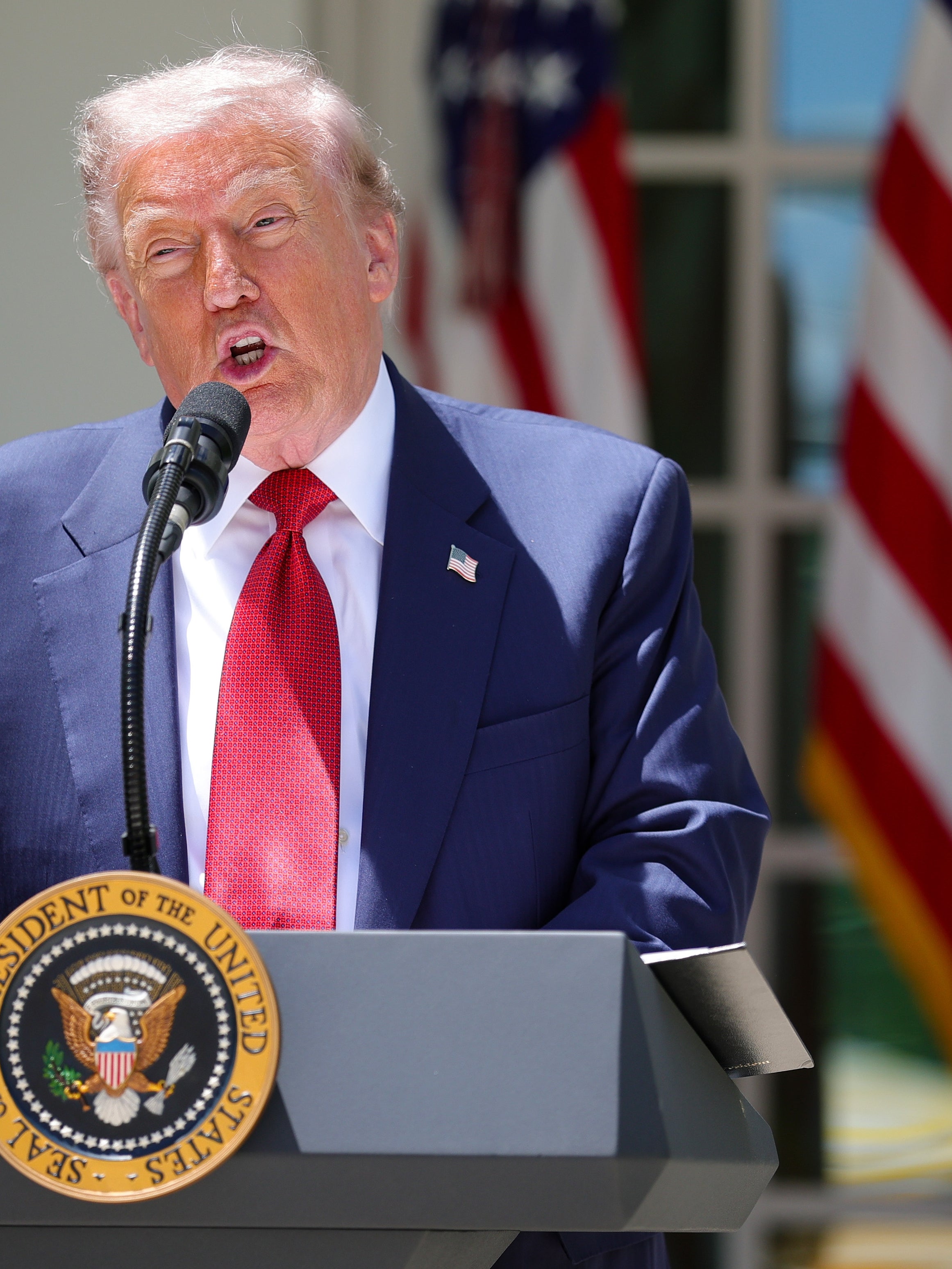 A idiosyncratic   speaking astatine  a podium with a statesmanlike  seal, successful  beforehand   of respective  American flags