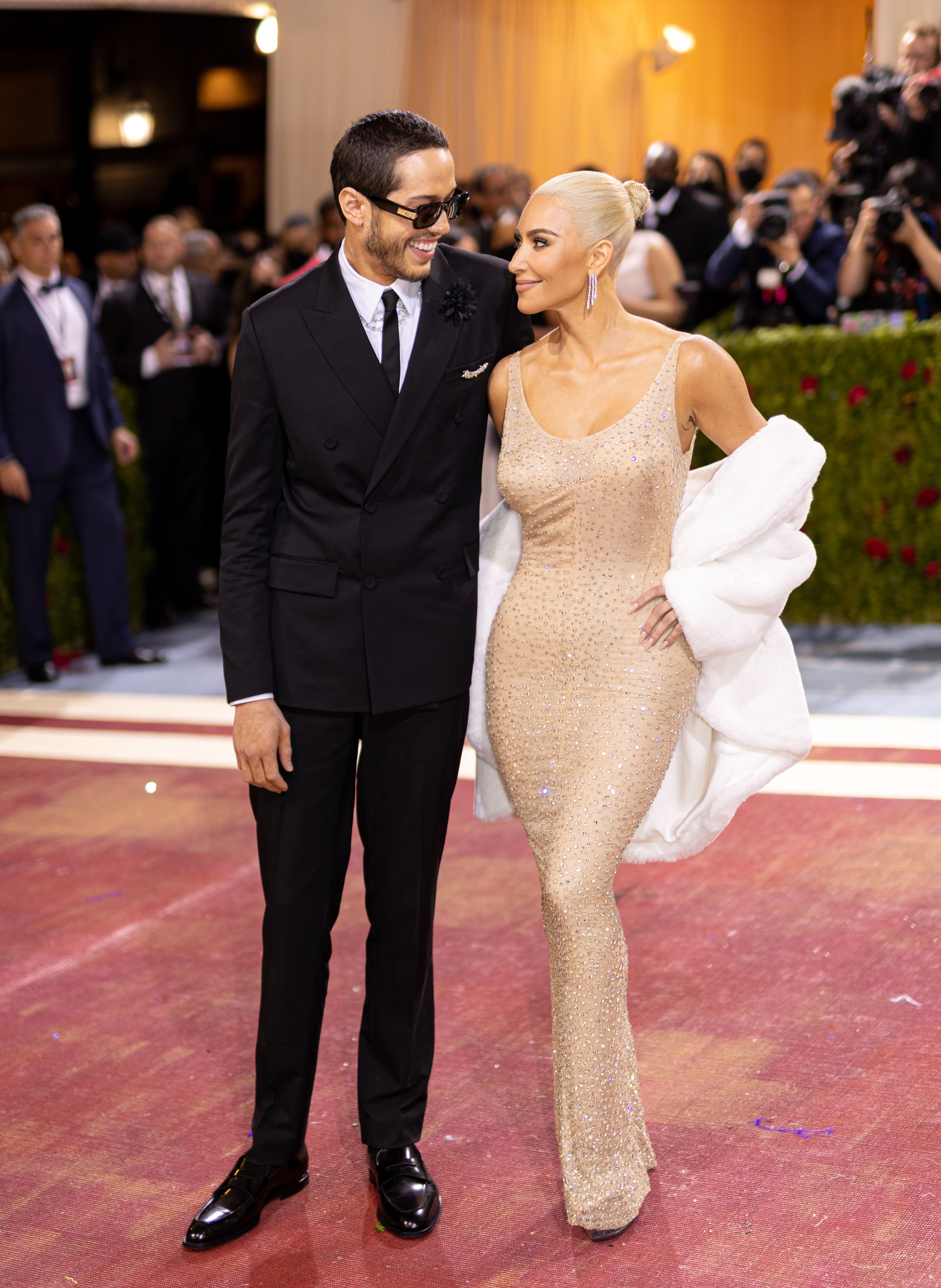 Pete i dress og solbriller med Kim, som har på seg en glitrende kjole