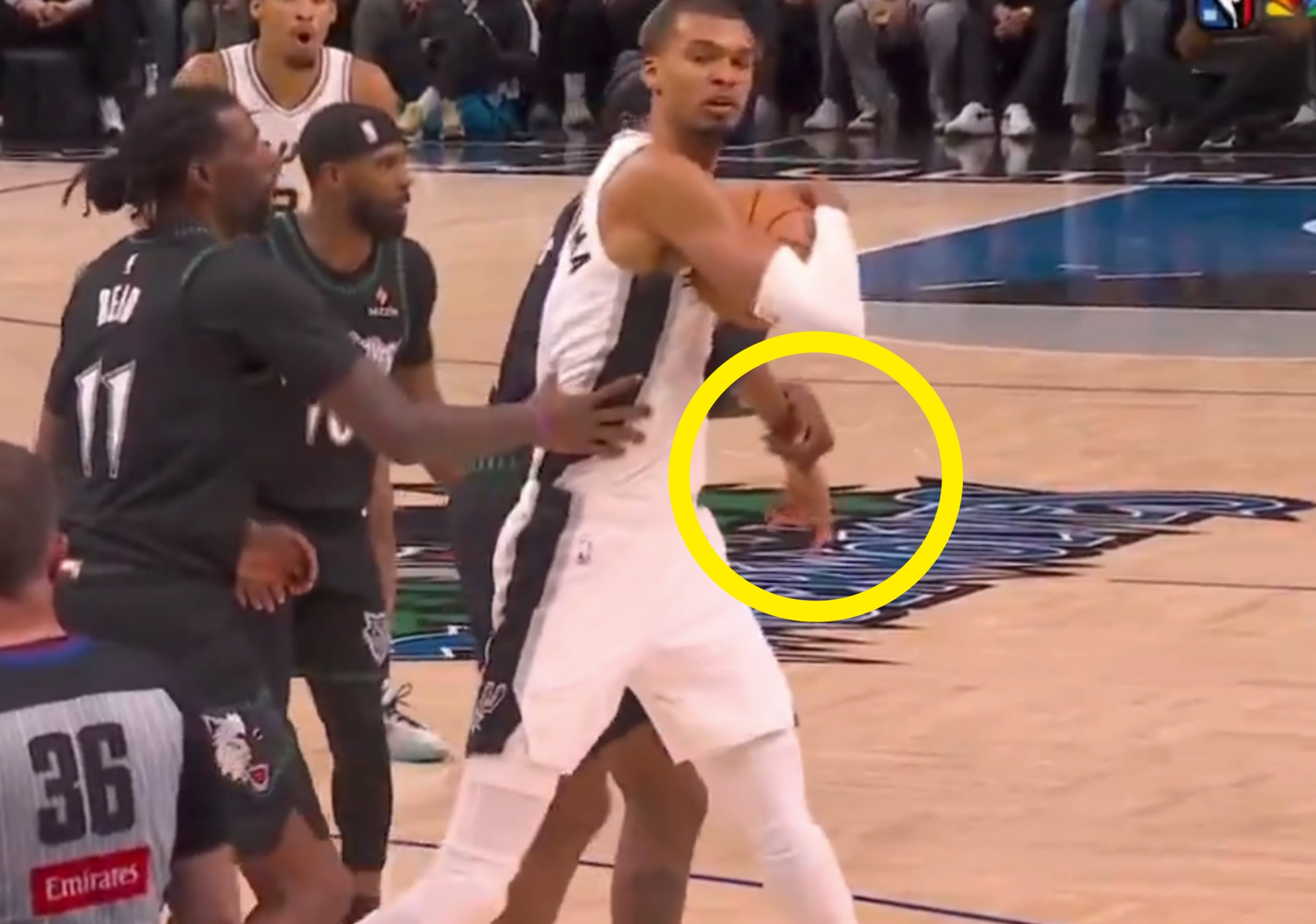 Basketball subordinate    successful  a achromatic  jersey holds the shot  connected  an indoor tribunal  portion    being guarded by opponents during a game