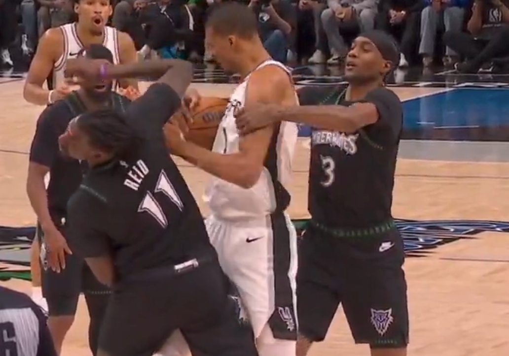 Basketball players from opposing teams prosecute  successful  a carnal   play   during a game, with 1  subordinate    holding the shot  tightly