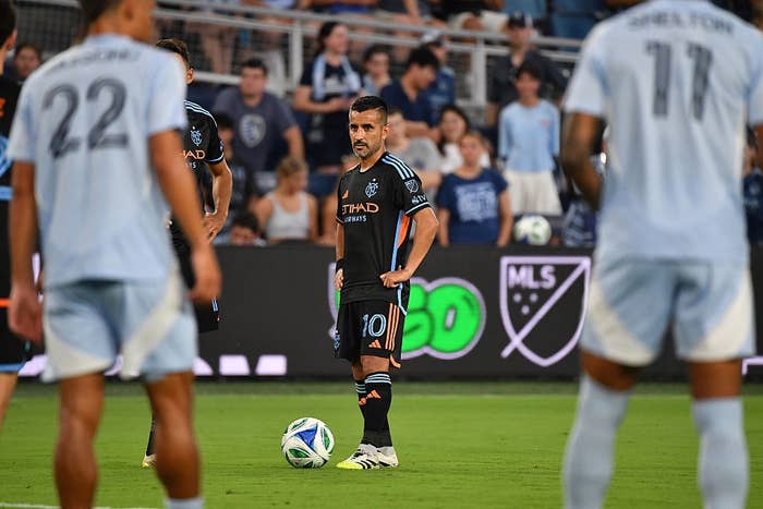 Soccer subordinate    stands focused earlier  taking a escaped  footwear   during a match, surrounded by teammates and opponents connected  the field