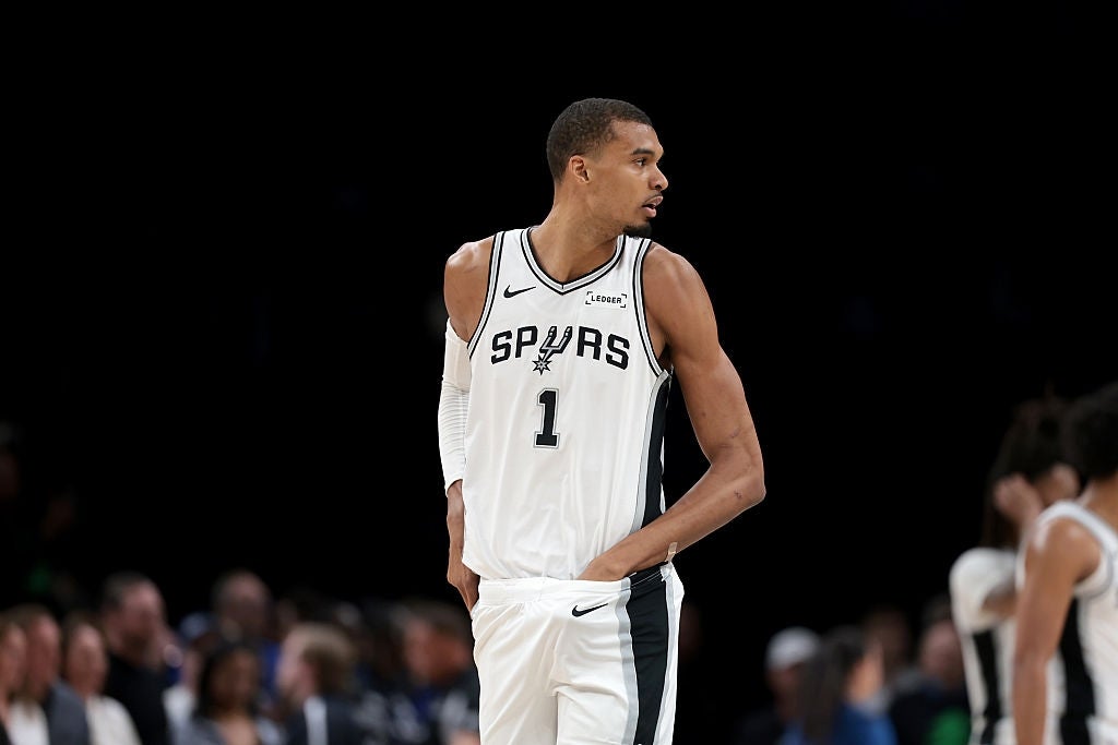 Basketball subordinate    successful  Spurs jersey connected  tribunal  during game, focused and acceptable   to play