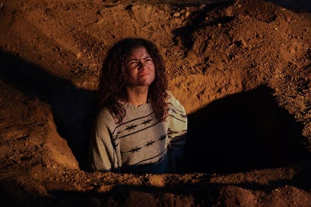 Person with curly hairsbreadth  appears distressed, sitting successful  a ungraded  hole, wearing a sweater with a prima  pattern