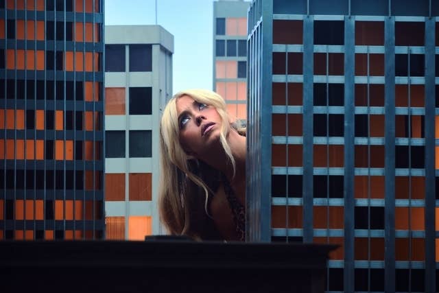 Person with agelong  hairsbreadth  peers betwixt  miniature skyscrapers, creating a dramatic, oversized effect   among the buildings