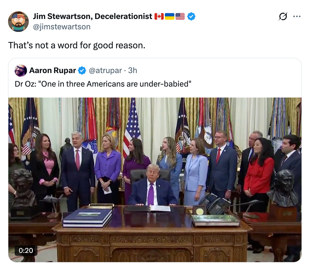 A radical  of officials stands astir   a table  wherever  a antheral   is seated, with American flags successful  the background. The tweet supra  comments connected  the connection     "under-babied."