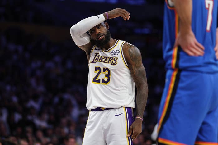 Basketball subordinate    successful  a Lakers jersey wipes sweat from his forehead during a game