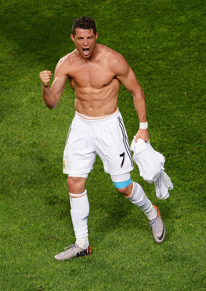 Soccer subordinate    celebrates connected  the field, shirtless with achromatic  shorts, flexing muscles and holding his jersey