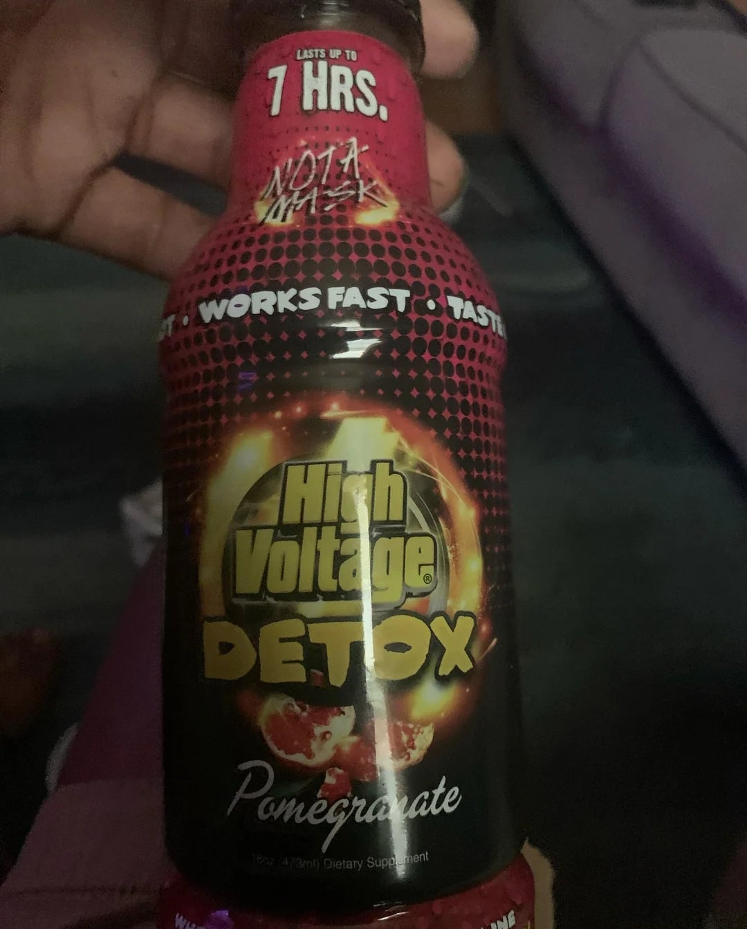 High Voltage Detox pomegranate flavor bottle held in hand, claims to work fast and last 7 hours