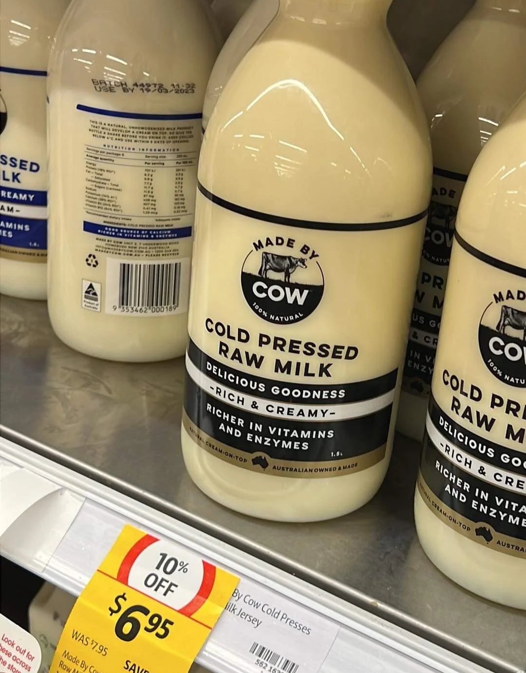 Bottles of "Made by Cow" cold-pressed raw milk on a store shelf