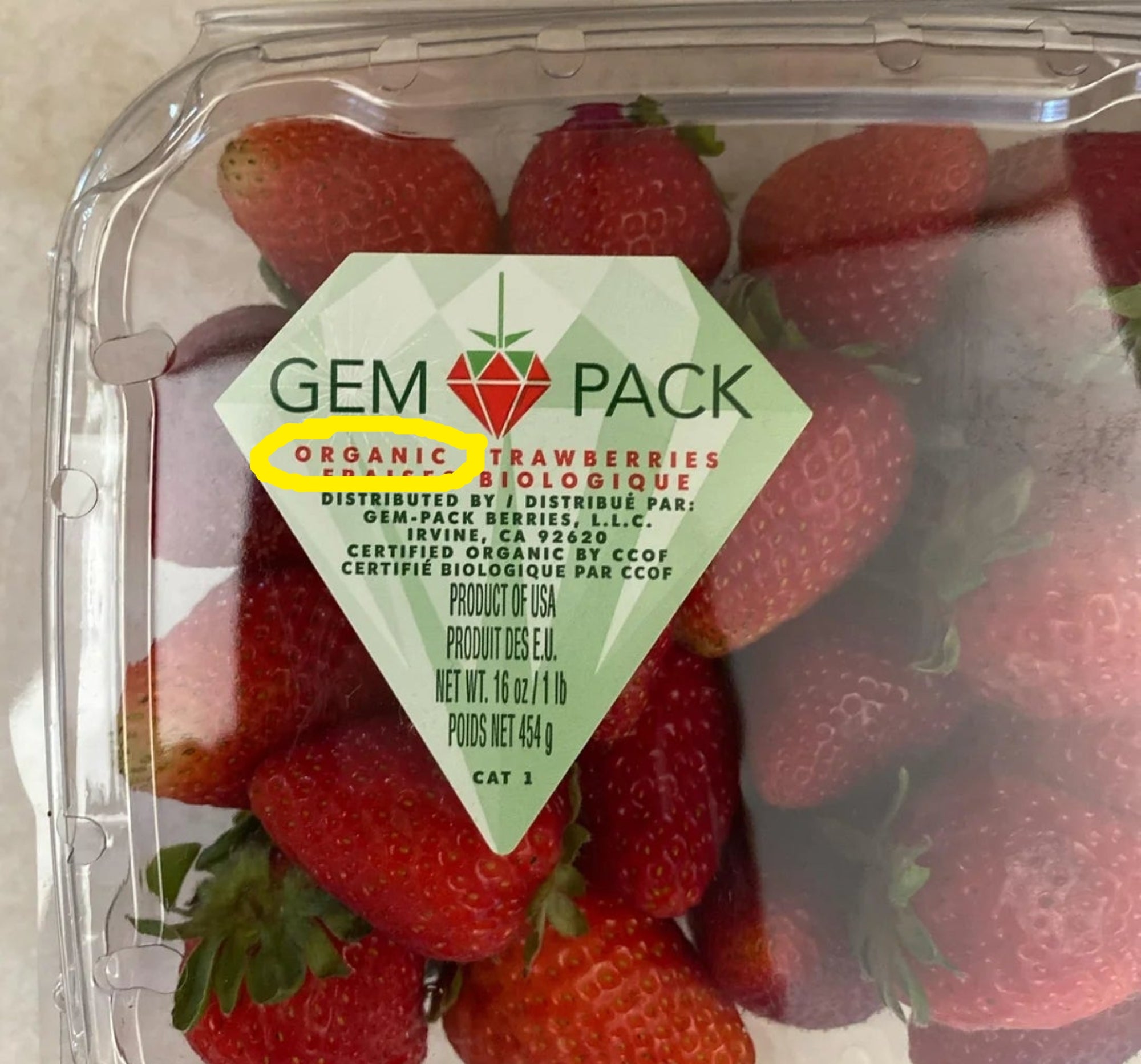 Pack of organic strawberries labeled "Gem Pack," displayed in a plastic container