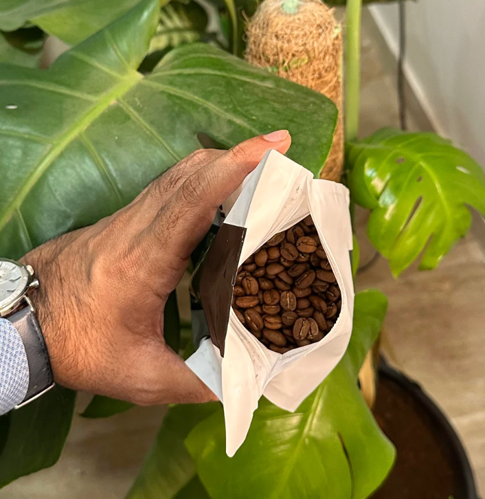 Reddit-innlegg som viser en person som holder australske kaffebønner over en plante, med diskusjoner om innkjøp av kaffe i r/IndiaCoffee fellesskapsforum