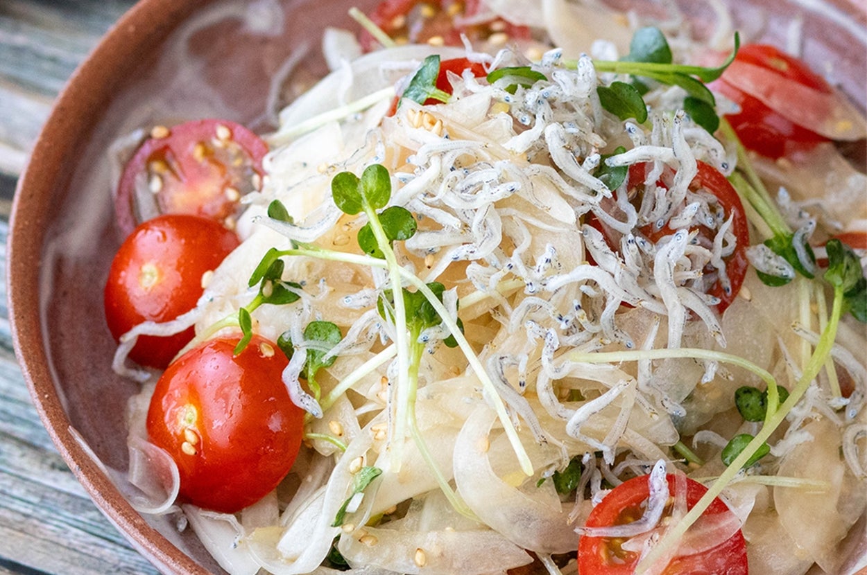 小皿に盛られたサラダ。トマト、豆苗、玉ねぎのスライス、しらすがのっている。
