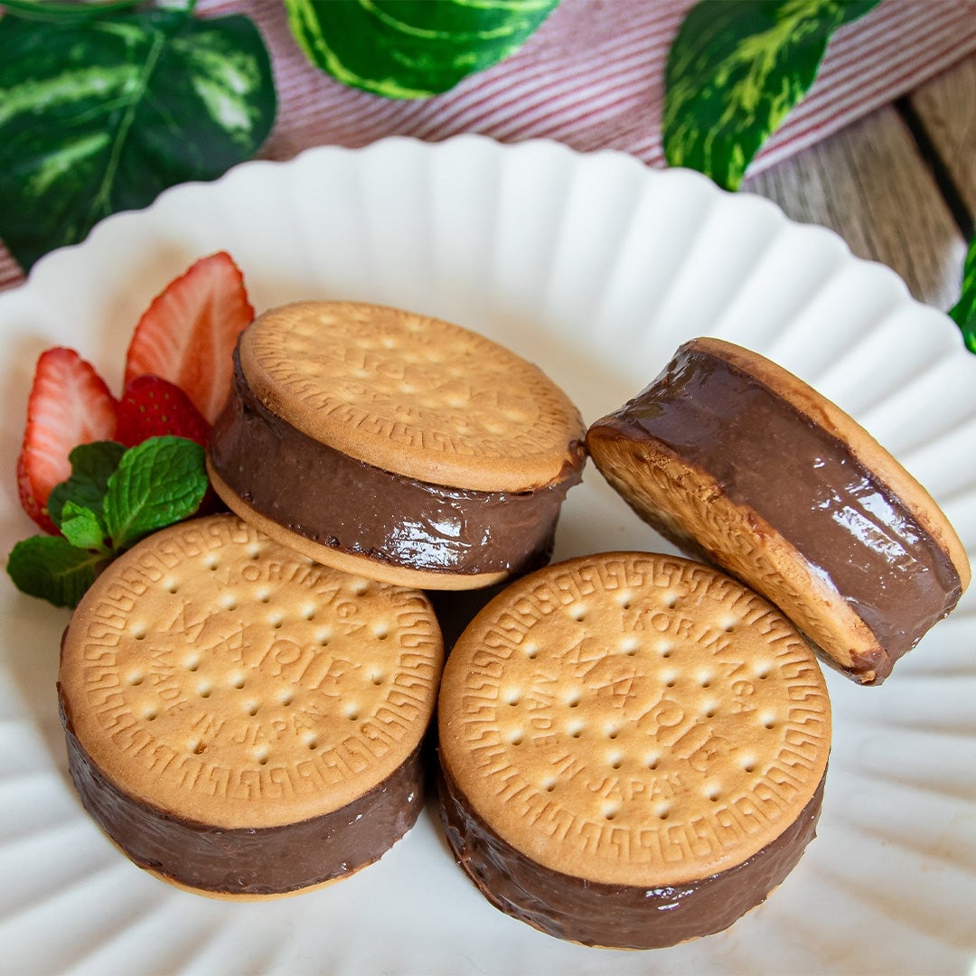 お皿に盛られたチョコレートサンドビスケットといちご、ミントの飾り。