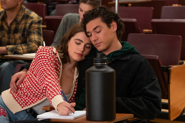 Two young adults beryllium   intimately  successful  a lecture hall; 1  is penning  portion    the different   rests their caput  affectionately connected  their shoulder