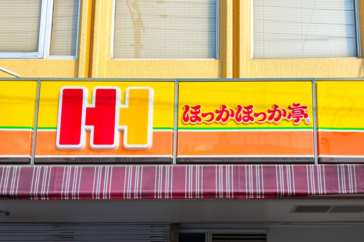 ほっかほっか亭の店舗看板。「H」と日本語の店名が書かれている。